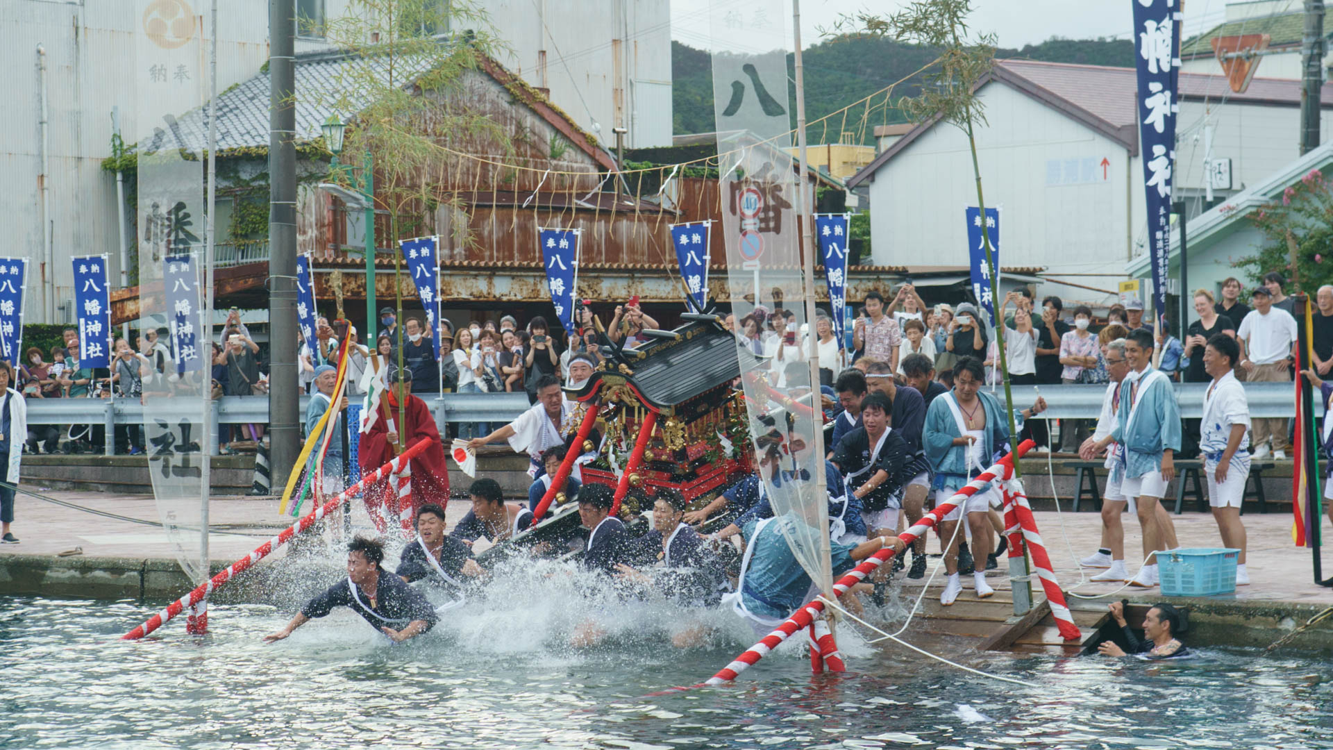 神輿海中神事にて水しぶきを上げて海に入る神輿
