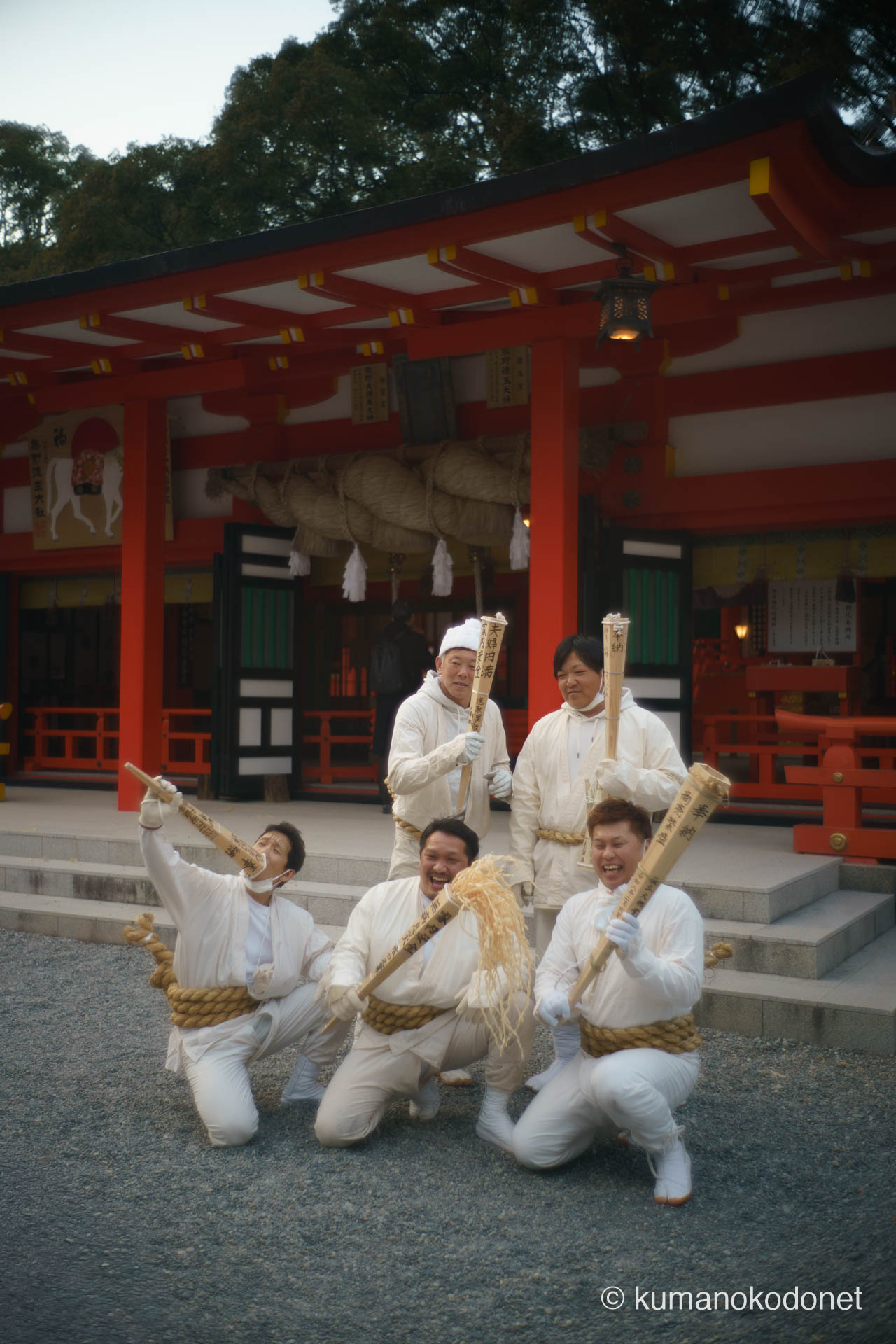 熊野速玉大社の境内で、松明を掲げながら気勢を上げる上り子たちの情景。白装束の集団が放つ熱狂と、これから神倉山へ向かう高揚感が拝殿の朱色に映える、新宮の活力を象徴する一枚。 ｜ Kumano Hayatama Taisha, Shingu, Wakayama ｜ SONY α7 ｜ 2026