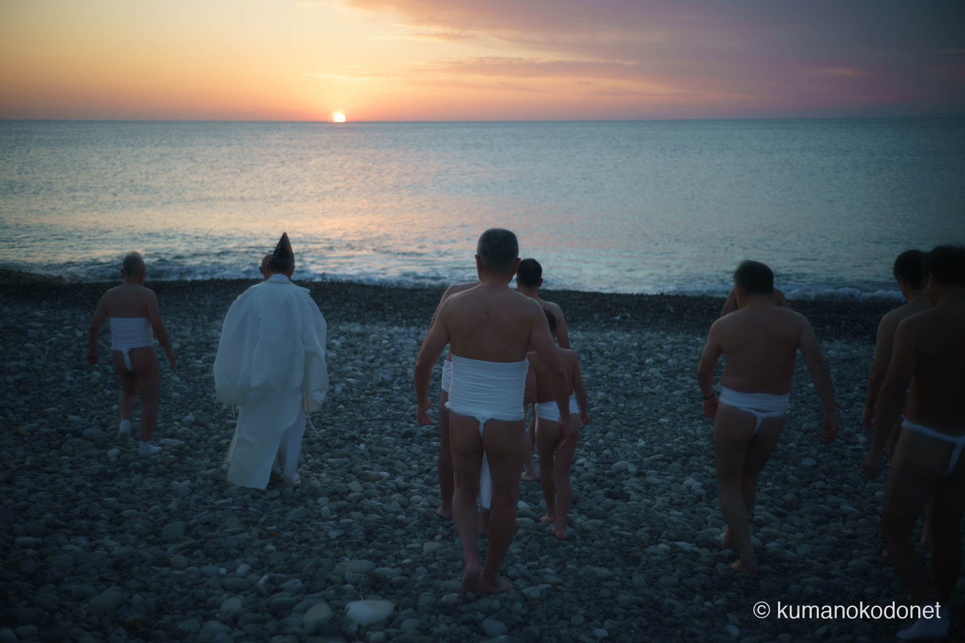 祈りを終え、一斉に太平洋へと駆け出す上り子たちの後ろ姿。白装束と、朝日に輝く波しぶきが交差する瞬間の記録。 ｜ Oujigahama, Shingu, Wakayama ｜ SONY α7 ｜ 2026