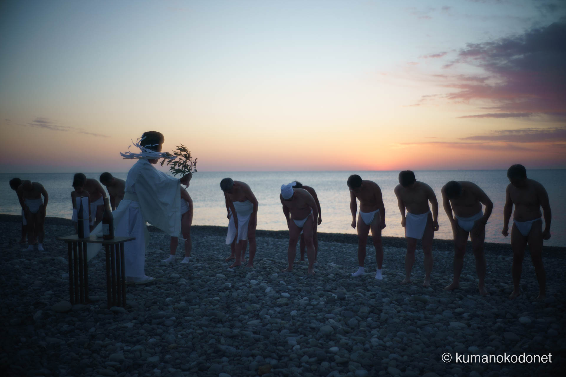 王子ヶ浜に並び、神倉神社に向かって深く遙拝する上り子たち。2026年の春のような陽光が彼らの白装束を照らしている。 ｜ Shingu, Wakayama ｜ SONY α7 ｜ 2026