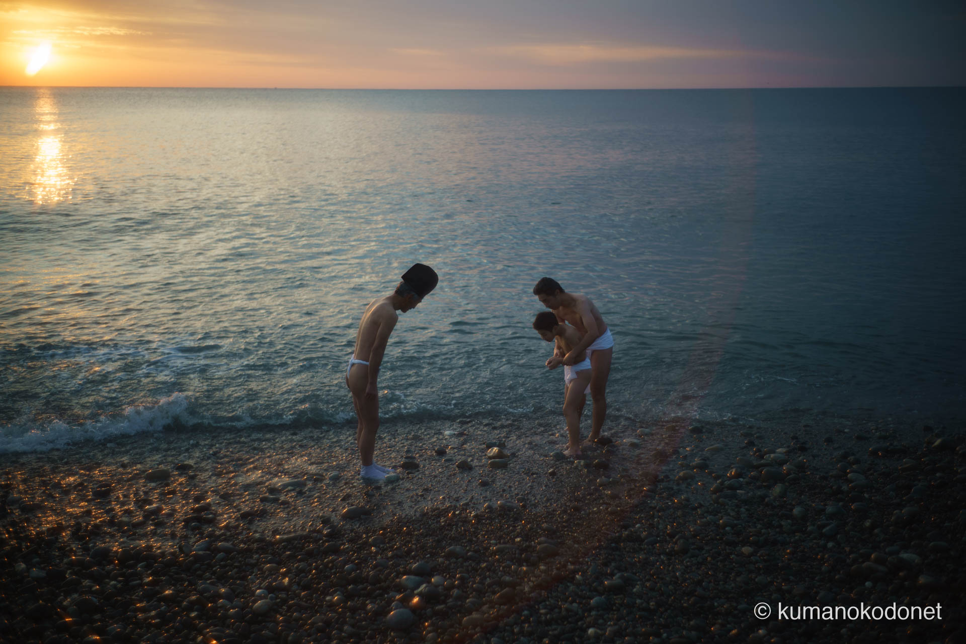 王子ヶ浜の砂浜で、潮垢離を終えたばかりの親子上り子と、静かに会釈を交わす斎主・福井鉄さん。2026年、新宮の伝統が育む敬意と絆が垣間見える瞬間の記録。 ｜ Oujigahama, Shingu, Wakayama ｜ SONY α7 ｜ 2026