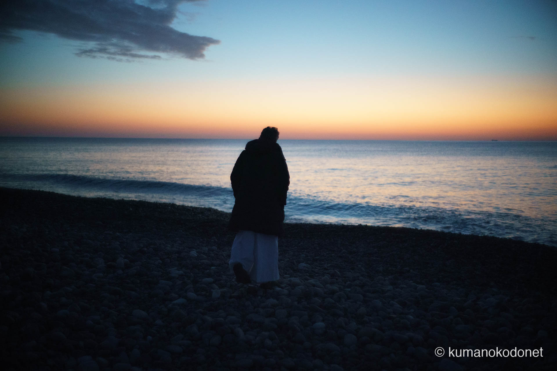 お燈祭りの朝、王子ヶ浜の静寂の中で海中みそぎの始まりを待つ斎主・福井鉄さんの後ろ姿を捉えた記録。 ｜ Oujigahama, Shingu, Wakayama ｜ SONY α7 ｜ 2026