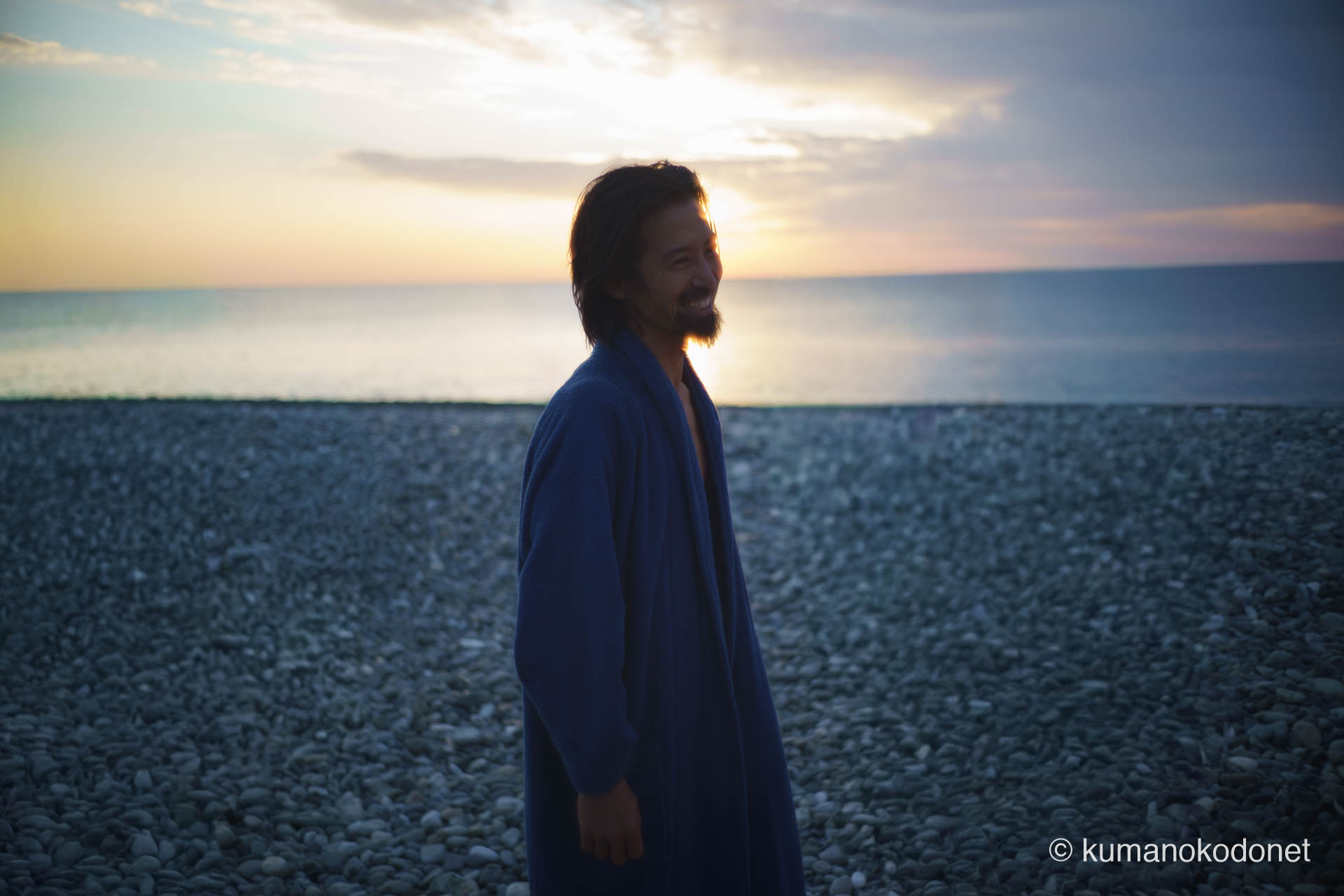 潮垢離を終え、バスローブを羽織って清々しい笑顔を見せる上り子。2026年の夜明け、厳しい禊を終えた後の達成感と多幸感に満ちた表情の記録。 ｜ Oujigahama, Shingu, Wakayama ｜ SONY α7 ｜ 2026
