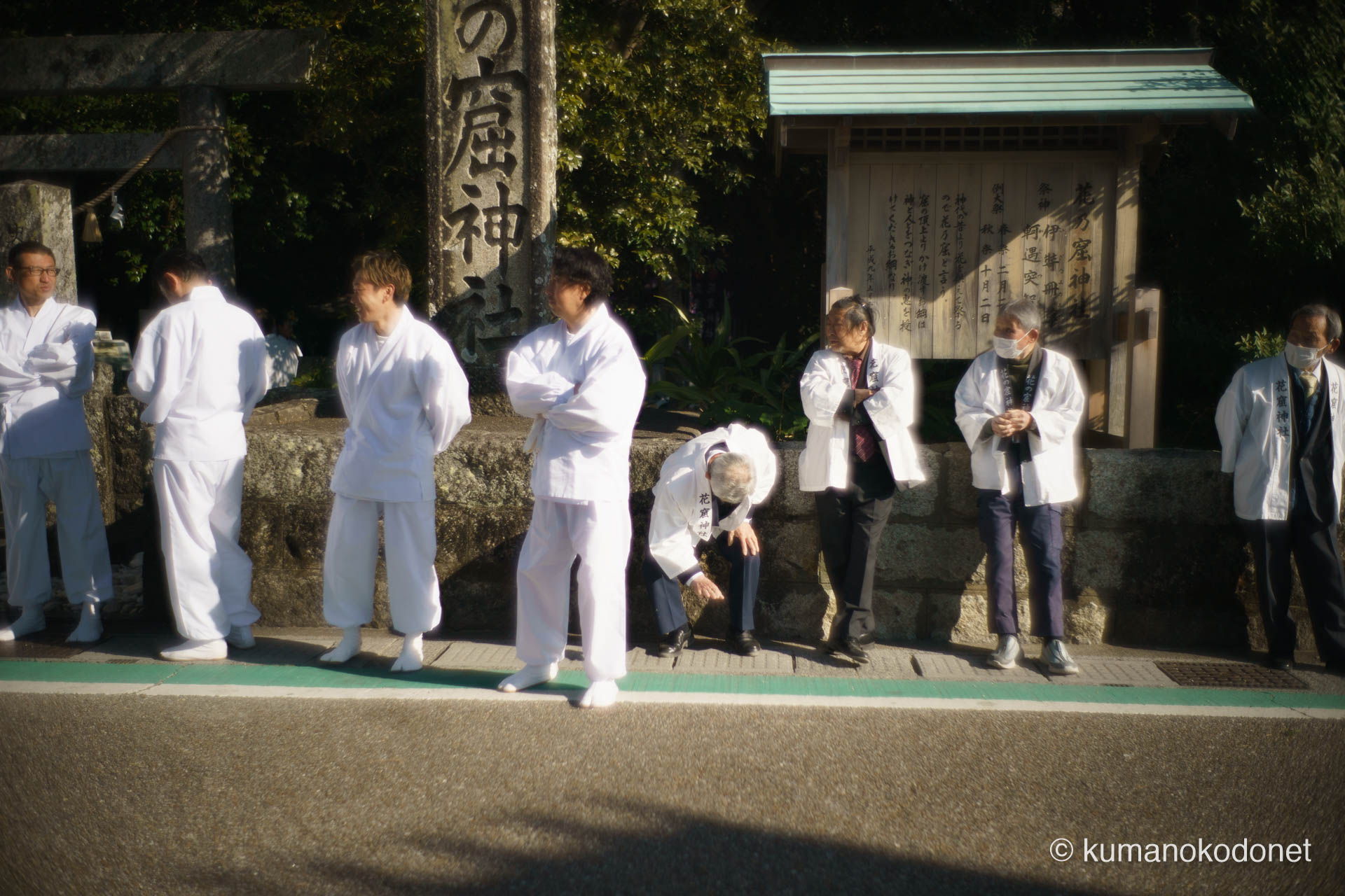 花の窟神社の石碑の傍らで待機する、白装束の「上り子(のぼりこ)」たち。御神体の頂上へ登り、お綱を操る重要な役割を担う男たちの静かな熱気。| Hananoiwaya Jinja, Arima, Kumano, Mie | SONY α7 | 2026
