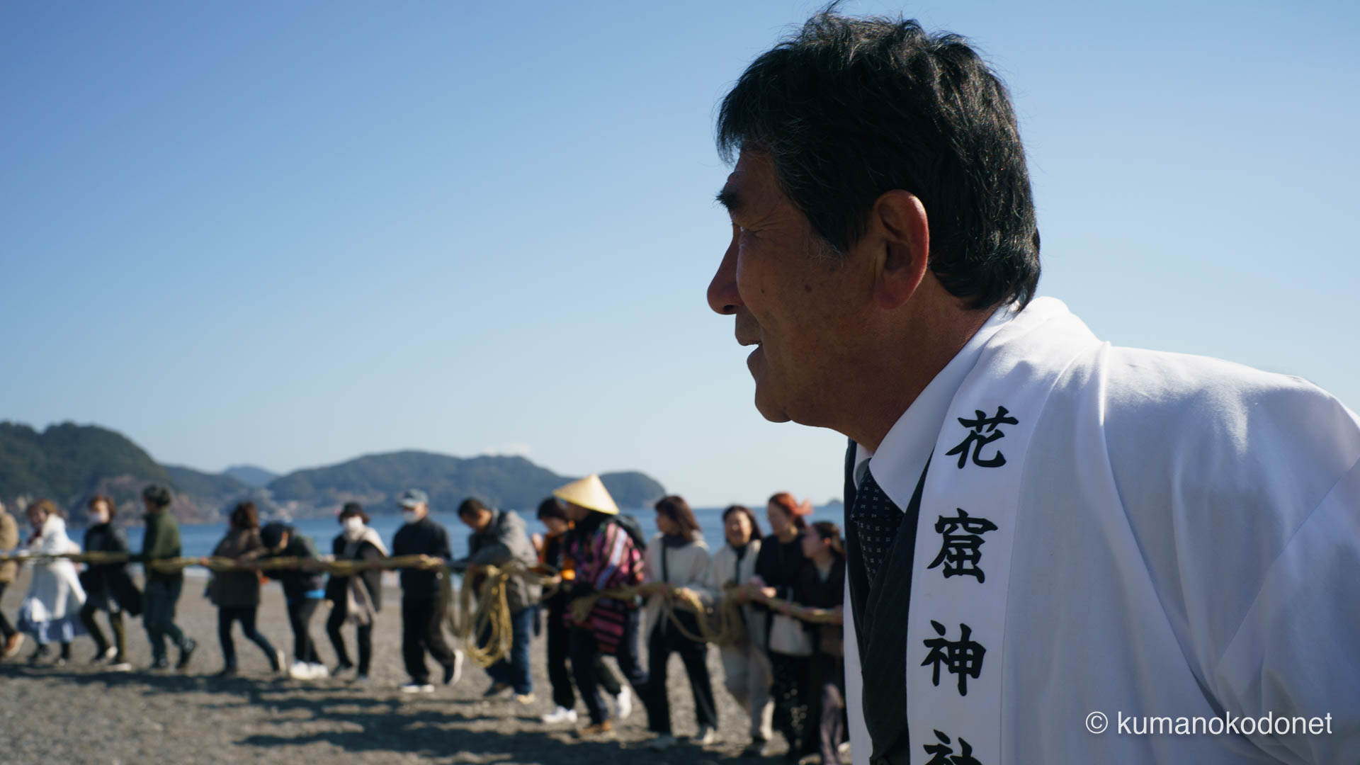 お綱掛け神事の成功を見据え、真剣な横顔で列を見守る氏子のクローズアップ。伝統を次世代へと繋ぐ決意が滲む、2026年神事の重みを伝えるポートレート。| Shichirimihama Beach, Hananoiwaya Jinja, Arima, Kumano, Mie | SONY α7 | 2026