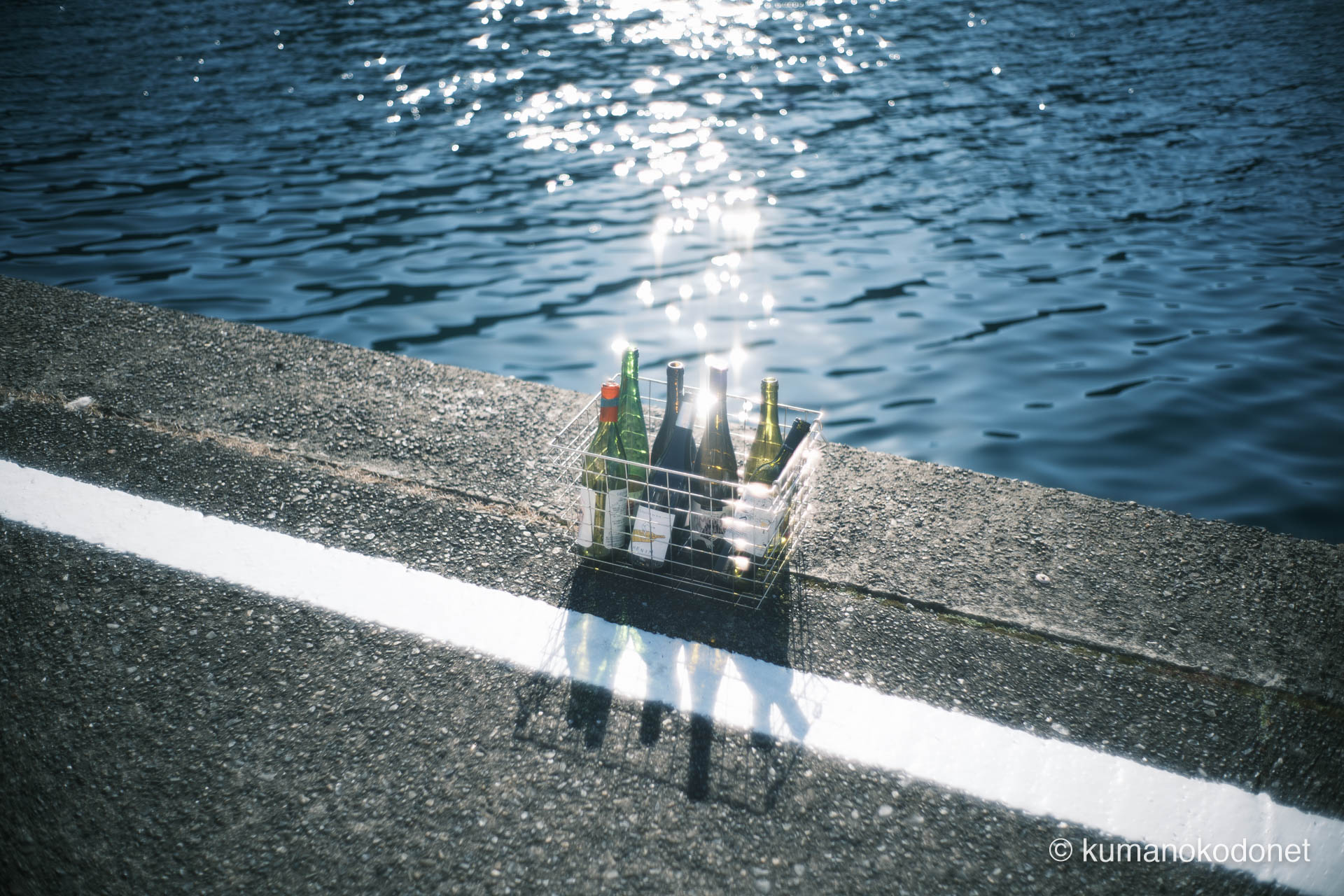 レストラン「Amail（アメイル）」の空き瓶。ガードレールのない道端に漂う港町の質感。｜ Kuki, Owase, Mie ｜ FUJIFILM GFX Classic Neg. ｜ 2026