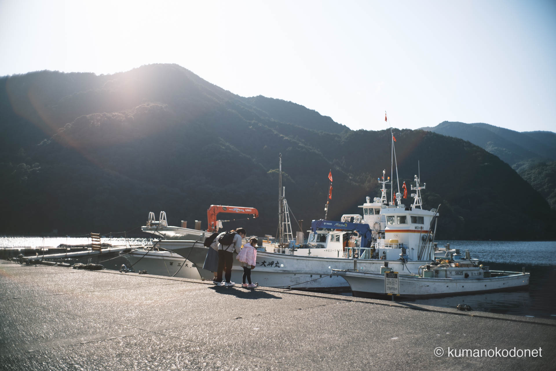 漁船を見守る親子。ガードレールのない岸壁が、家族の記憶をより親密なものにする。｜ Kuki, Owase, Mie ｜ FUJIFILM GFX Classic Neg. ｜ 2026