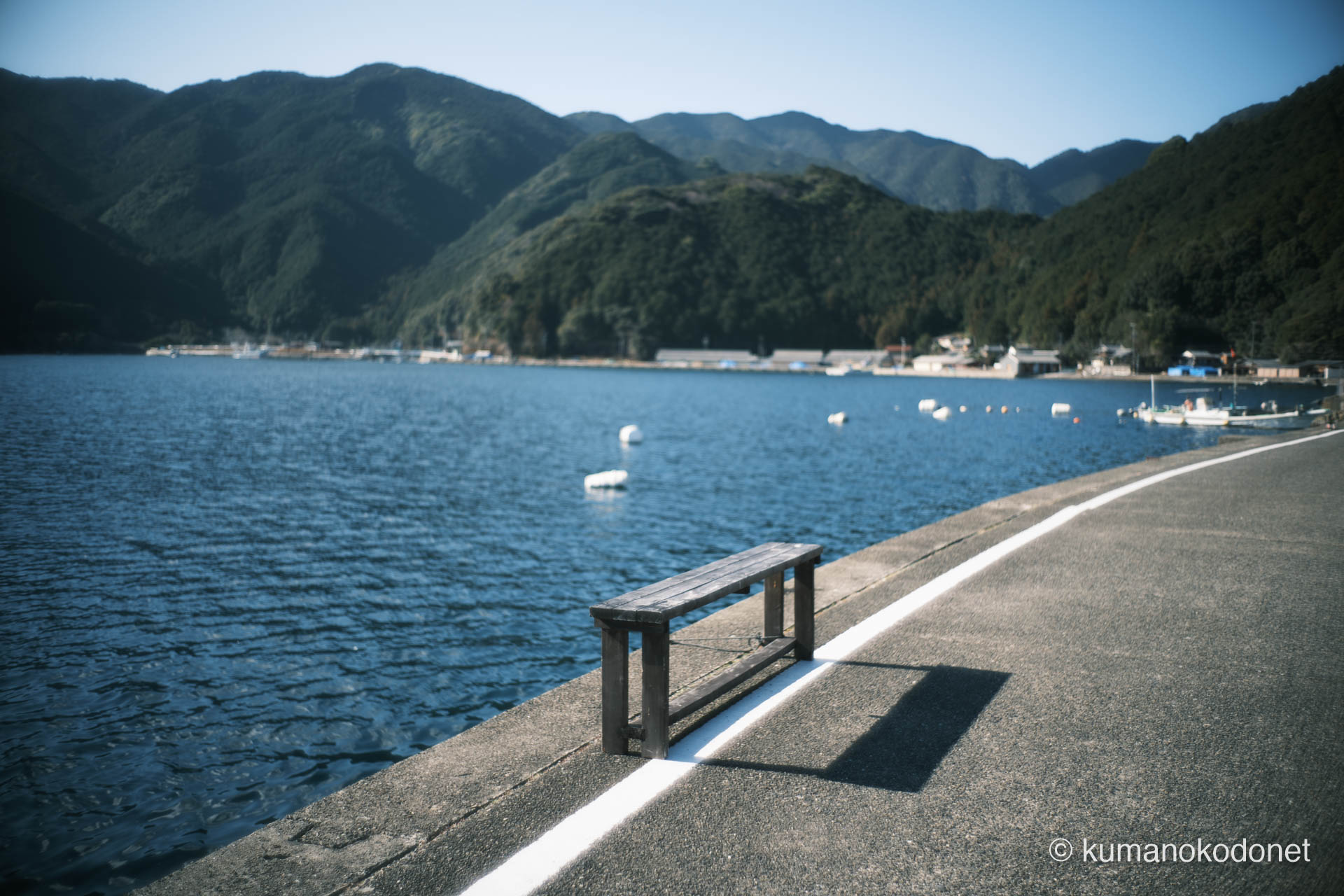 九鬼町 ｜ 三重県尾鷲市 ｜ ガードレールのない道沿いに置かれた木製ベンチ ｜ 2026 ｜ KVA