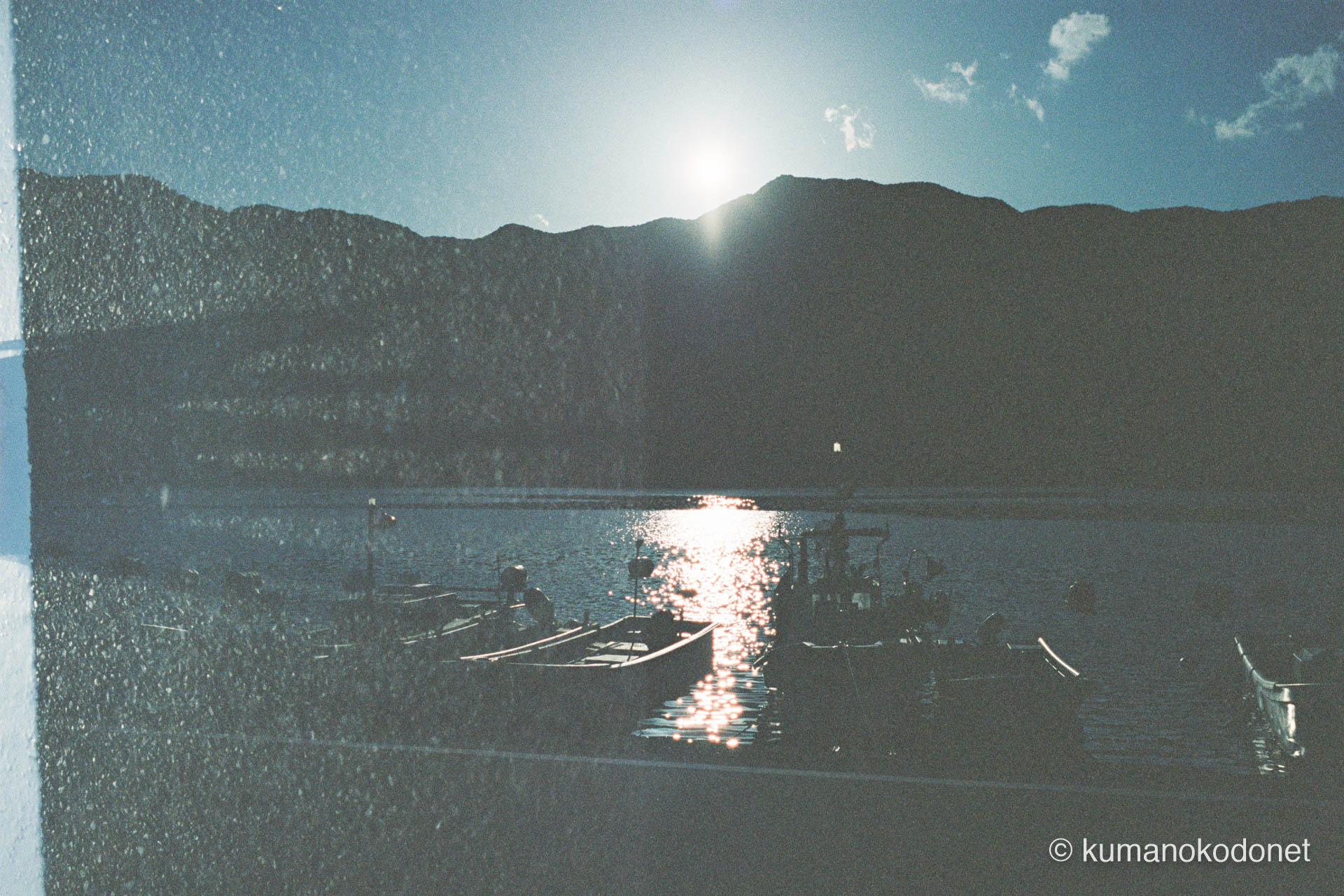 夕陽を反射して黄金色に輝く九鬼湾。波間に揺れる船影と、粒子感の中に溶けていく港町の黄昏。｜ Kuki, Owase, Mie ｜ Kodak Portra 400 ｜ 2026