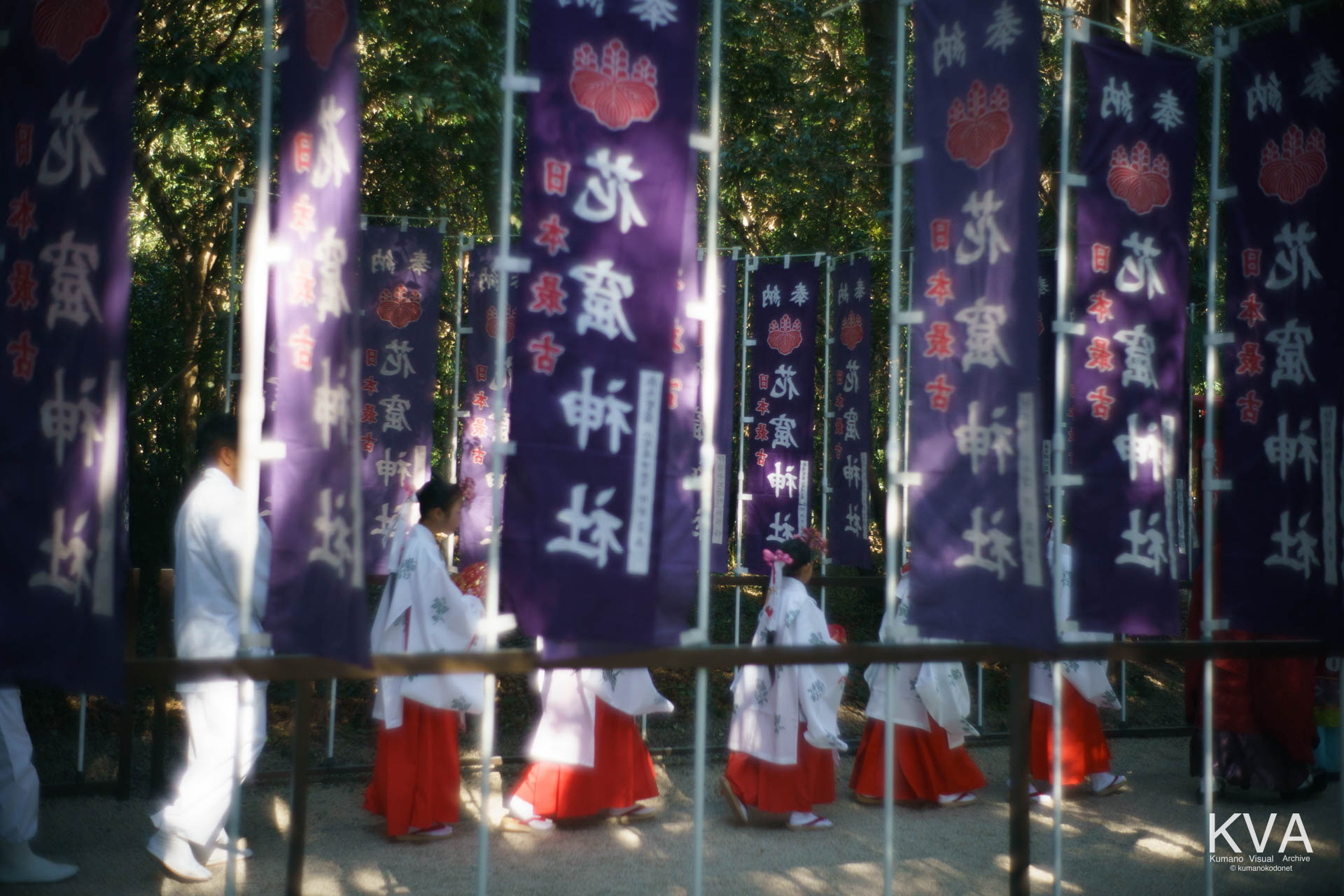 花の窟神社の幟と、御神体前へと移動する巫女たち