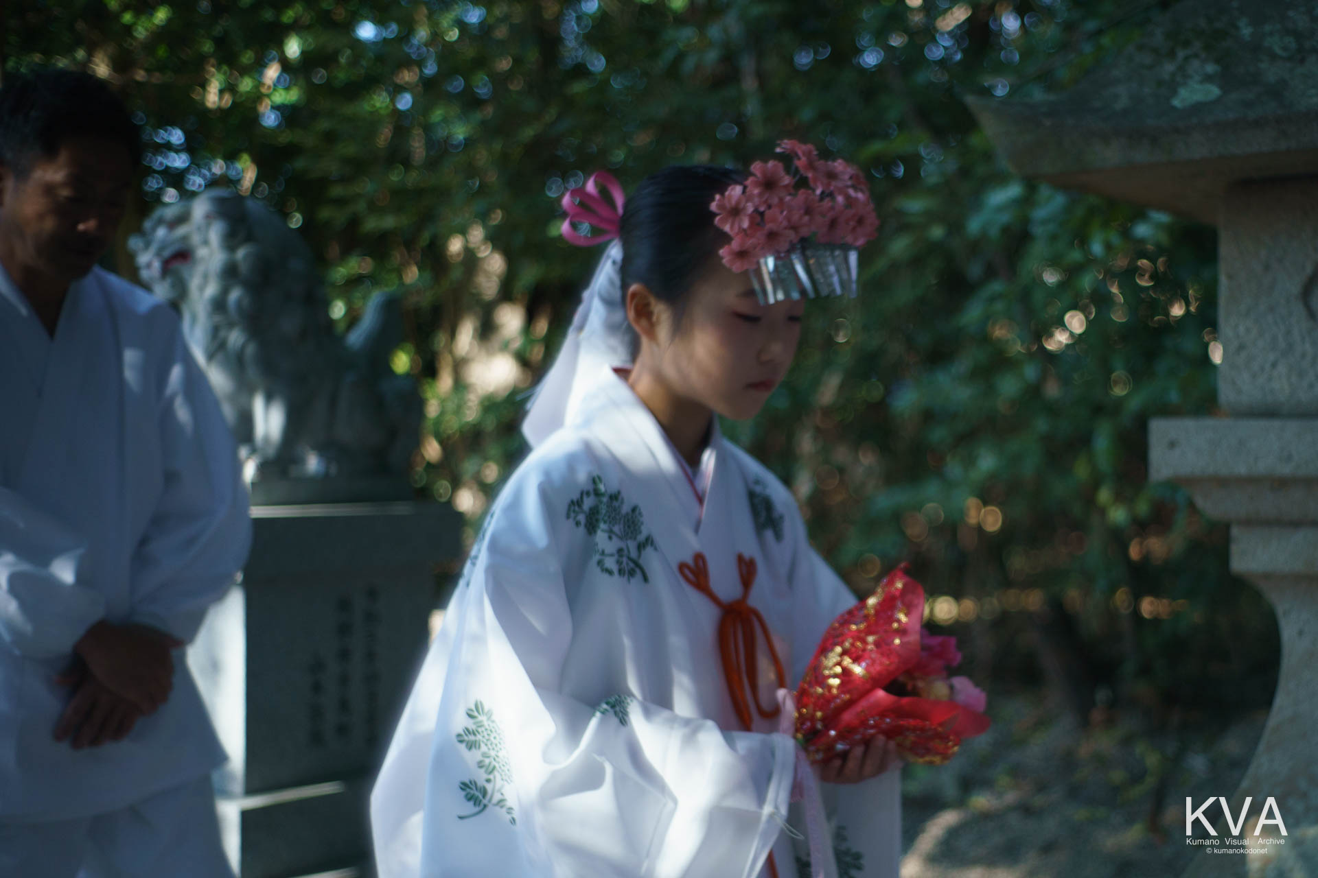 寒椿を携えて参道を歩む巫女