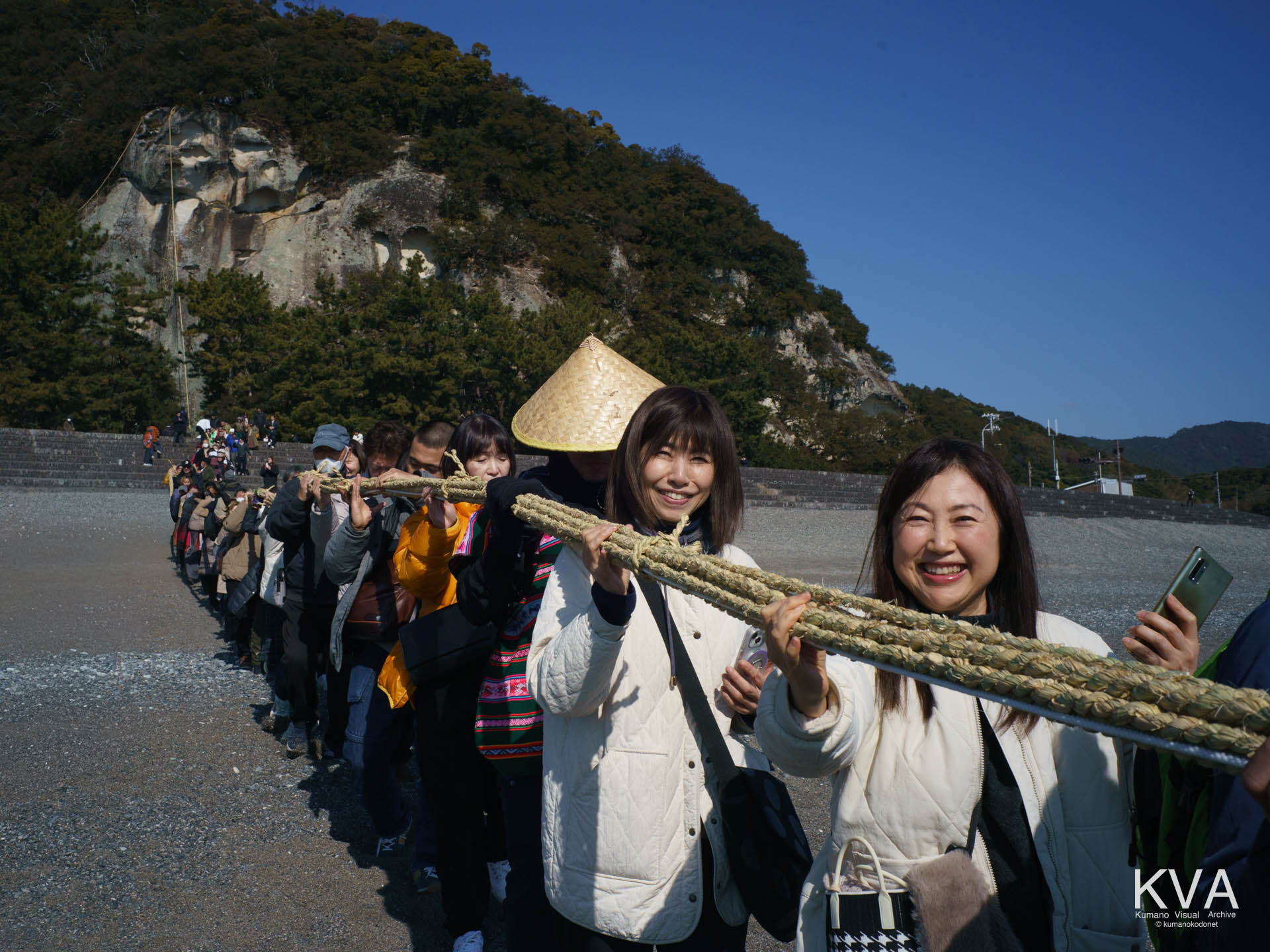 七里御浜でお綱を担ぎ歩む一般参加者たち