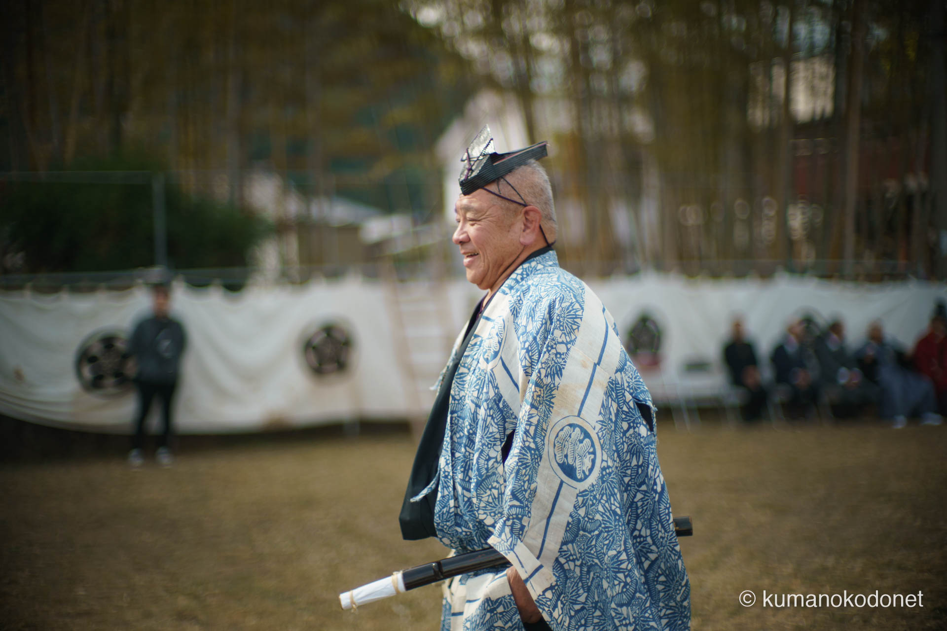 弓行事の最中、ふとした瞬間に晴れやかな笑顔を見せる射手。張り詰めた集中力が必要な神事の合間、地域の人々と共有する祭りの喜びがその表情から溢れ出す。伝統を担う者の等身大の魅力を捉えた一枚。| Tenma Tenjinja, Nachikatsuura, Wakayama | SONY α7 | 2026