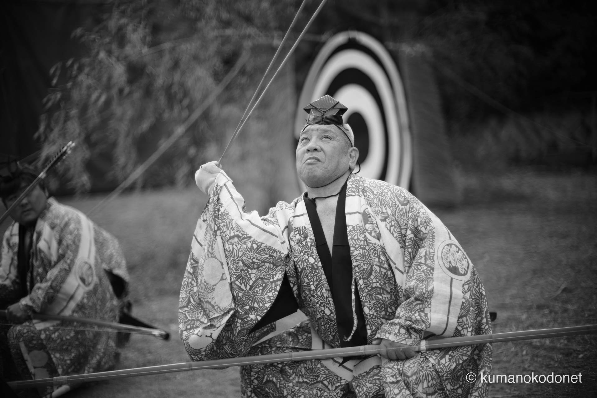 モノクロームの世界で、自身の弓の状態を厳かに確認する射手。一射ごとに繰り返される点検の所作は、道具への敬意と神事への深い没入を象徴する。背景の的が、これから放たれる一矢の緊張感を際立たせる。| Tenma Tenjinja, Nachikatsuura, Wakayama | SONY α7 | 2026