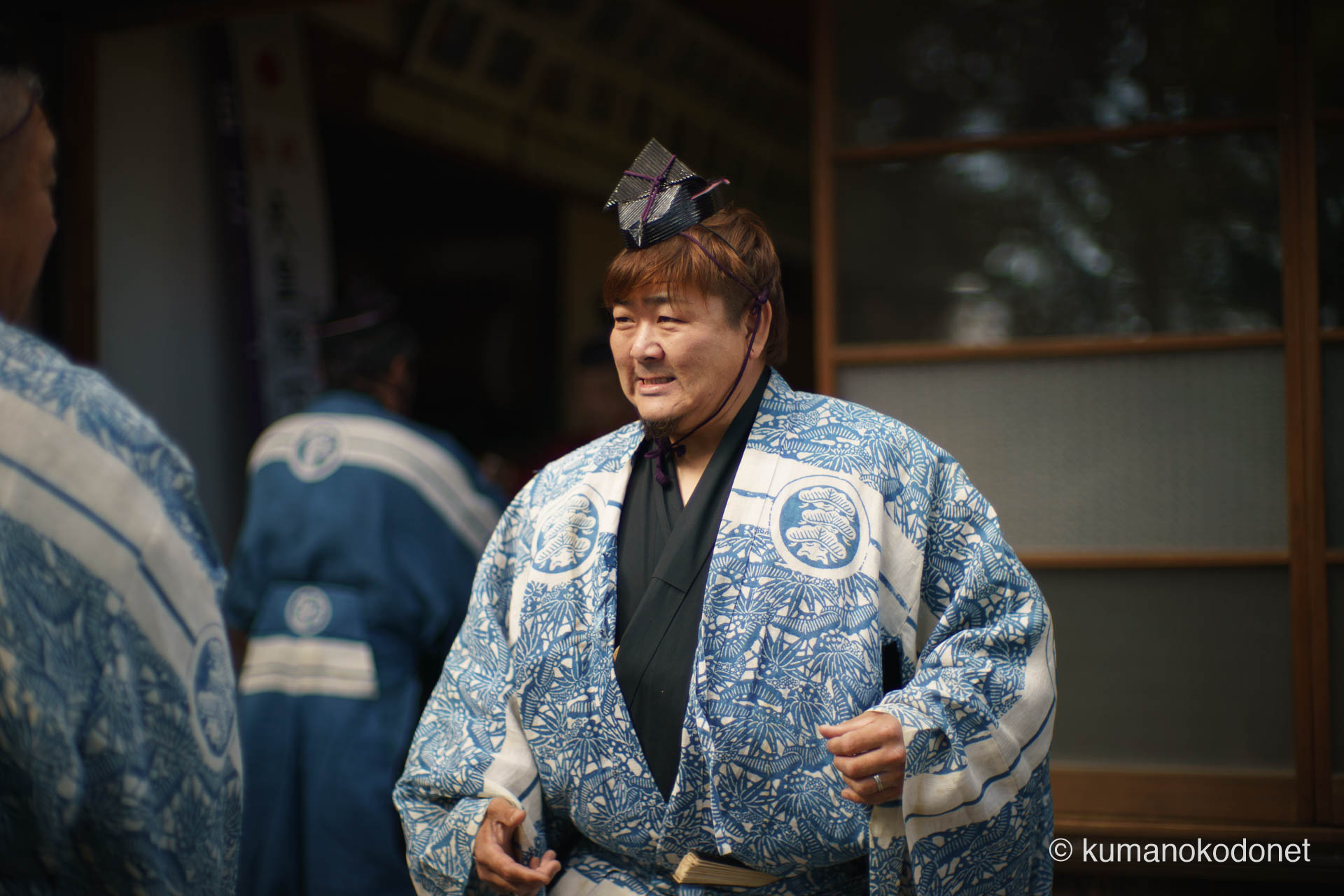 神酒を授かり伝統装束姿で笑顔を浮かべる射手