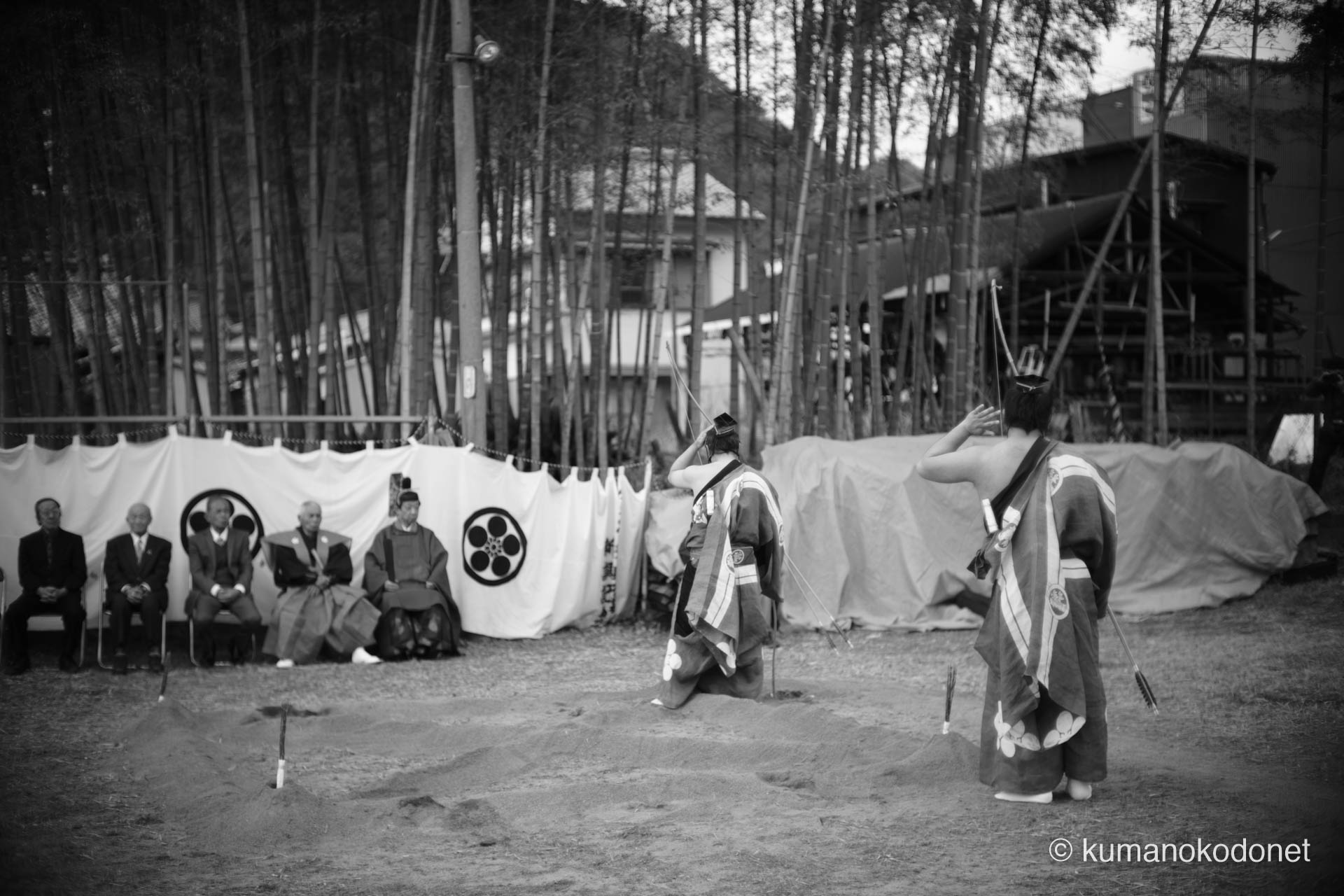 砂山の前で弓を掲げる二人の射手