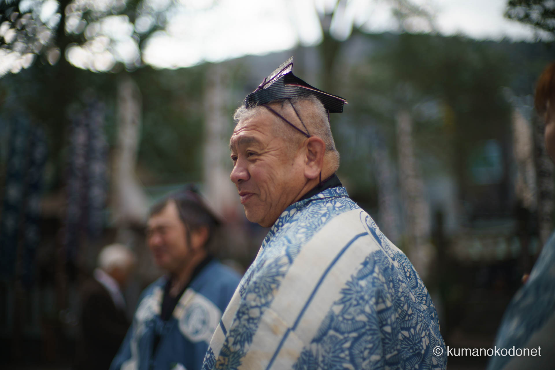 天満天神社の弓行事を控え、静かに精神を研ぎ澄ませる射手の横顔。神酒を授かり、伝統の青い装束を纏った男の視線の先には、射貫くべき的がある。祭りの喧騒の中で、一人静かに自らの役割を見つめる決意の表情。| Tenma Tenjinja, Nachikatsuura, Wakayama | SONY α7 | 2026