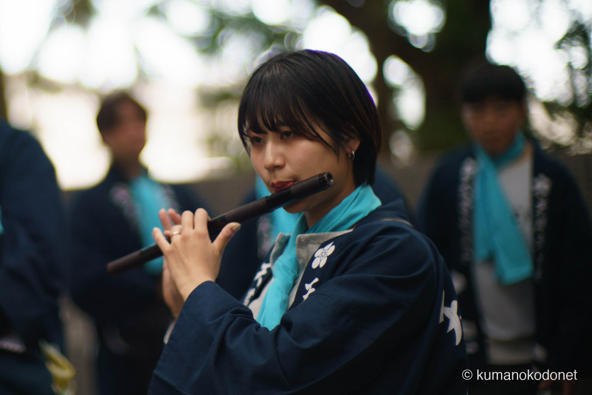 祭囃子に合わせて篠笛を奏でる女性