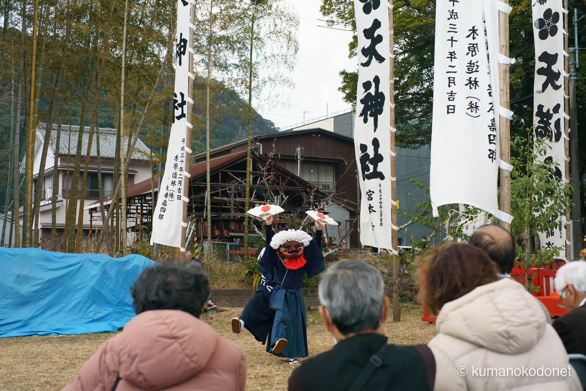 射場で日の丸の扇子を広げて舞う獅子