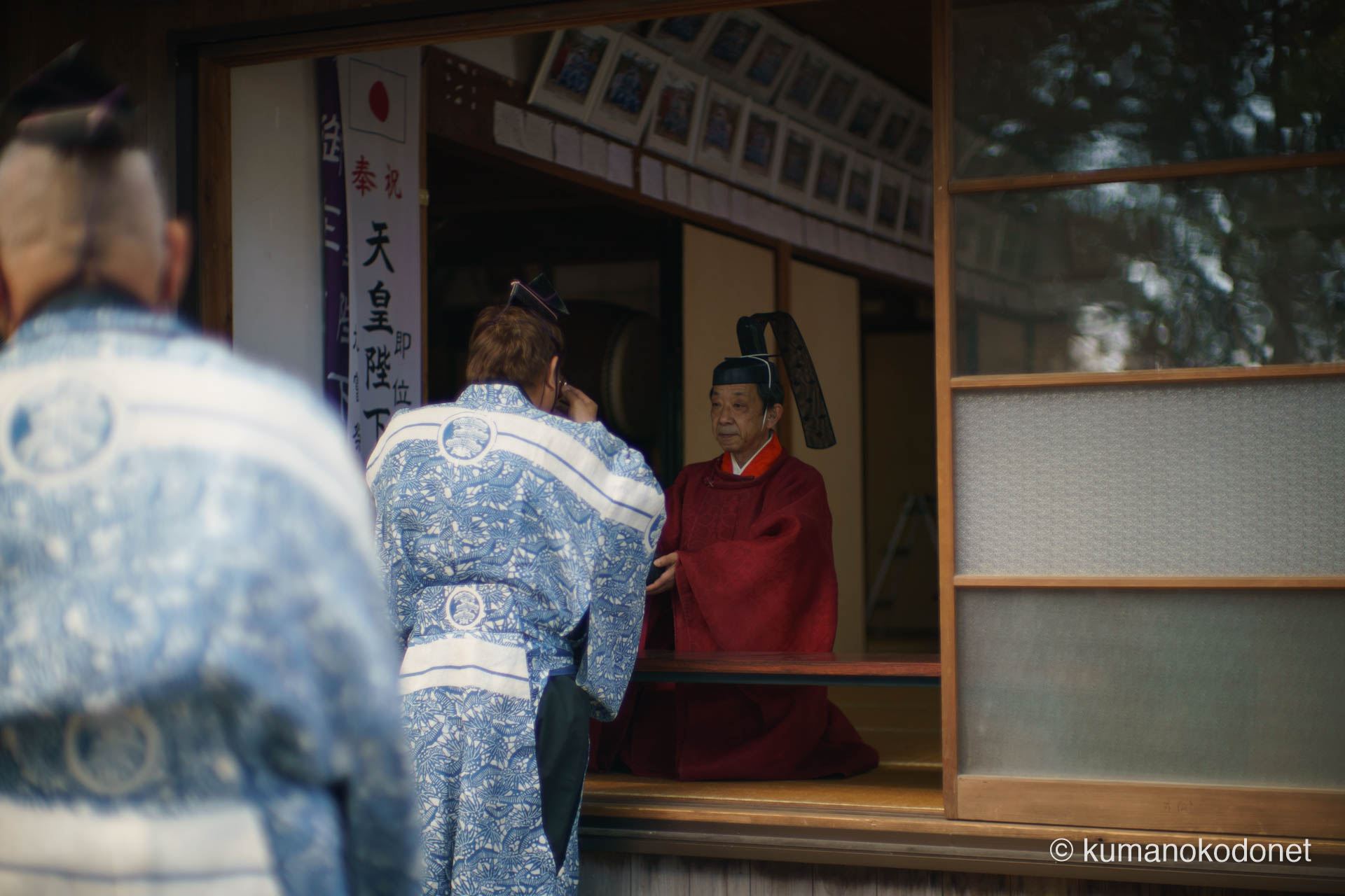 天満天神社の例大祭にて、献饌と玉串奉納の神事を終えた後、高橋正樹宮司から神酒(しんしゅ)を授かる参列者。これから始まる獅子舞奉納や弓行事という大舞台を前に、身を清め、神からの力を授かる一瞬の静寂。祭りの核心部へと向かう緊張感と高揚感が交差する情景。| Tenma Tenjinja, Nachikatsuura, Wakayama | SONY α7 | 2026