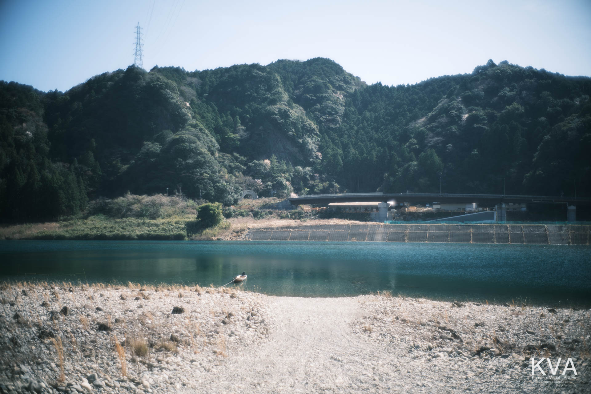 熊野川の河原に係留された一艘の川舟と対岸の風景
