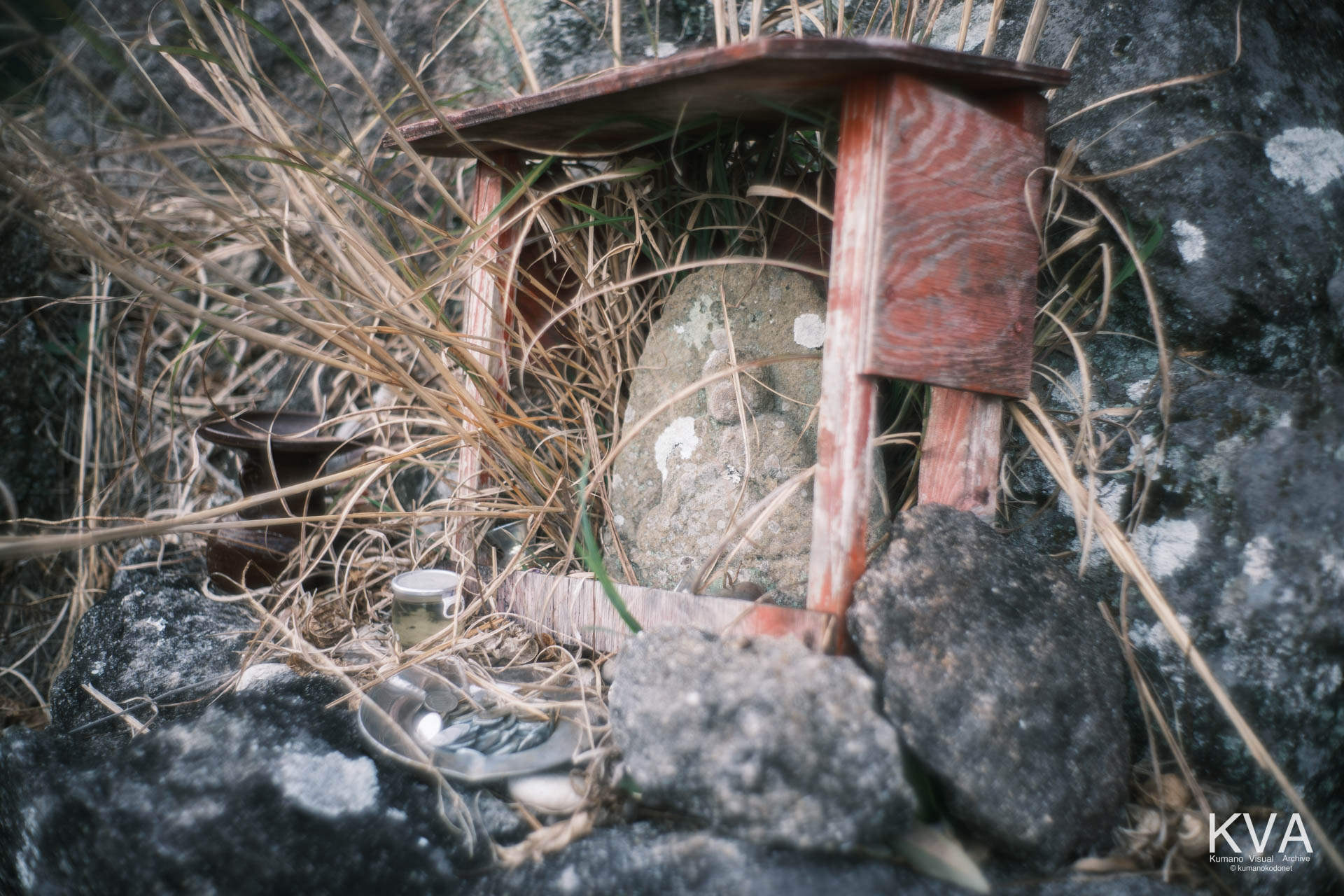 岩陰に安置された石仏とお賽銭の状況