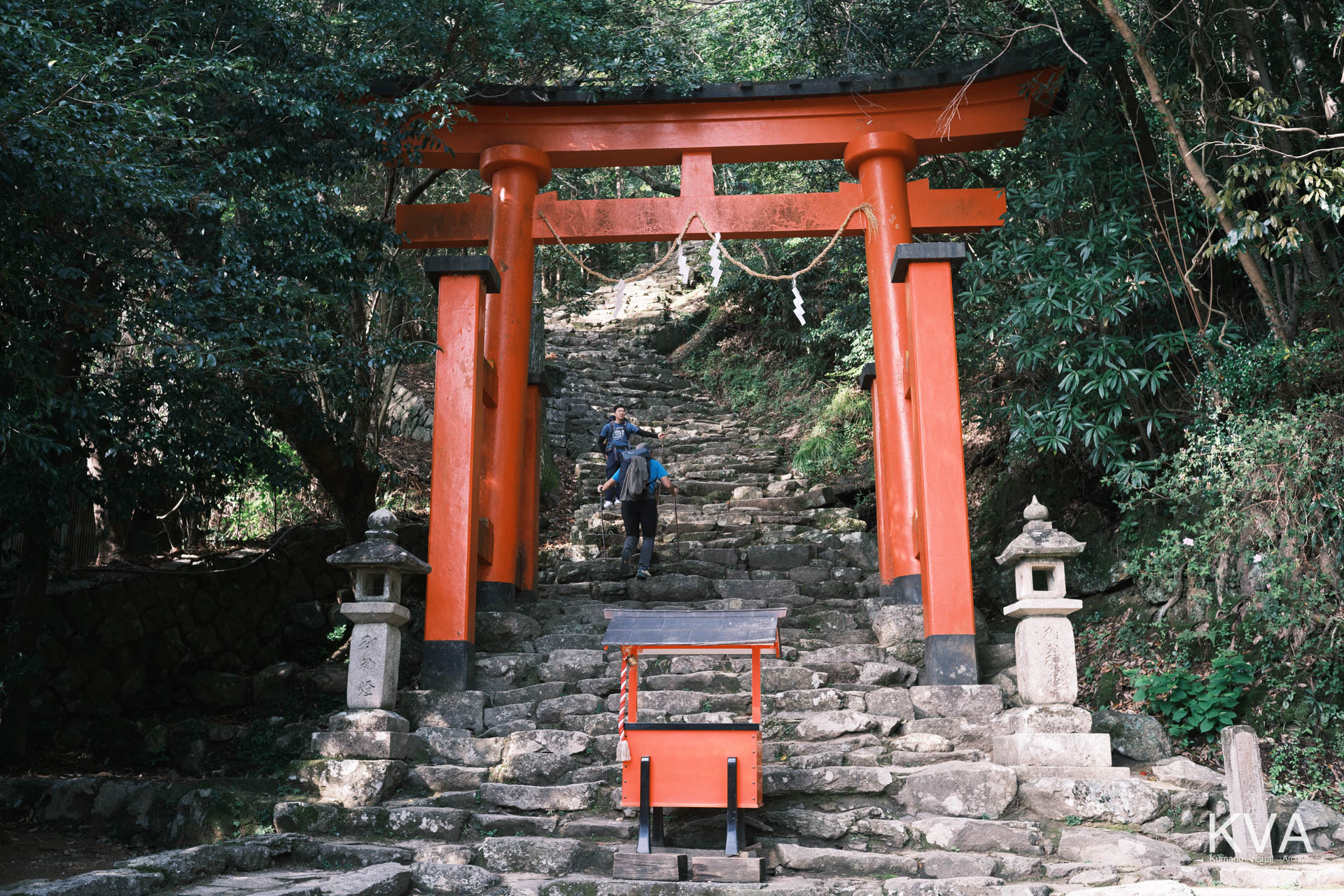 神倉神社の鳥居と、石段を登る観光客の後ろ姿