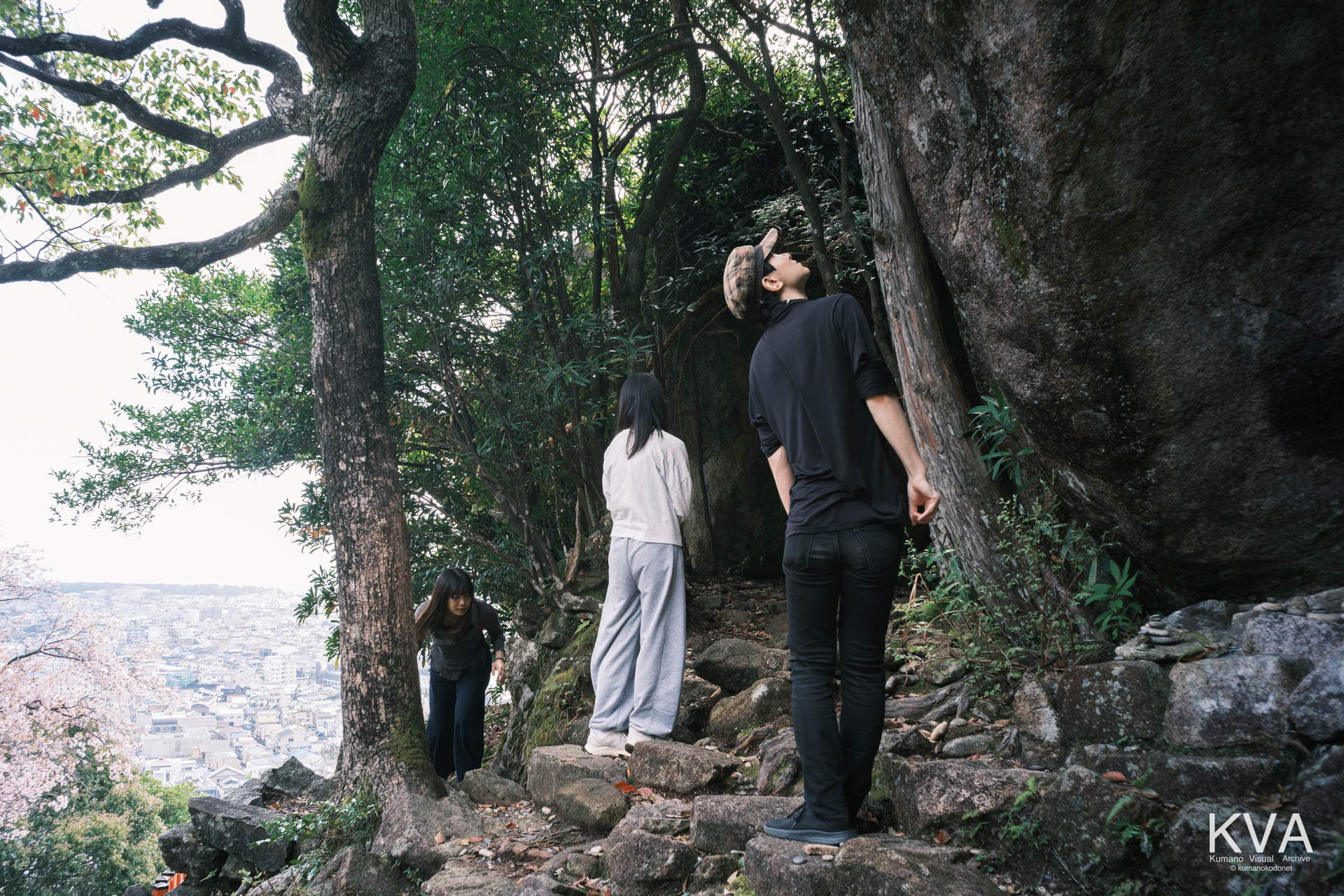 巨石を見上げる観光客の後ろ姿