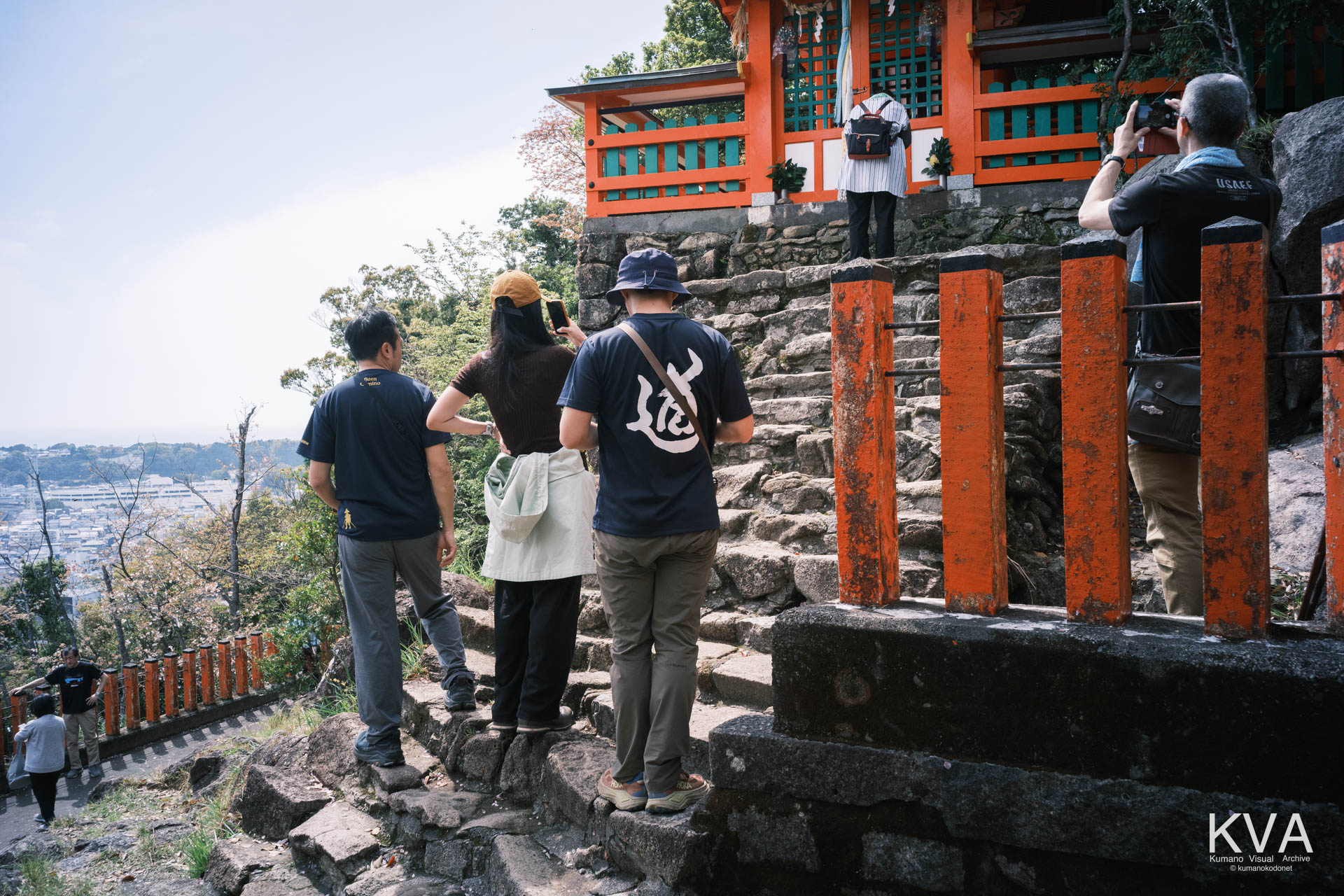 ゴトビキ岩を背景にスマートフォンで記念撮影をする観光客