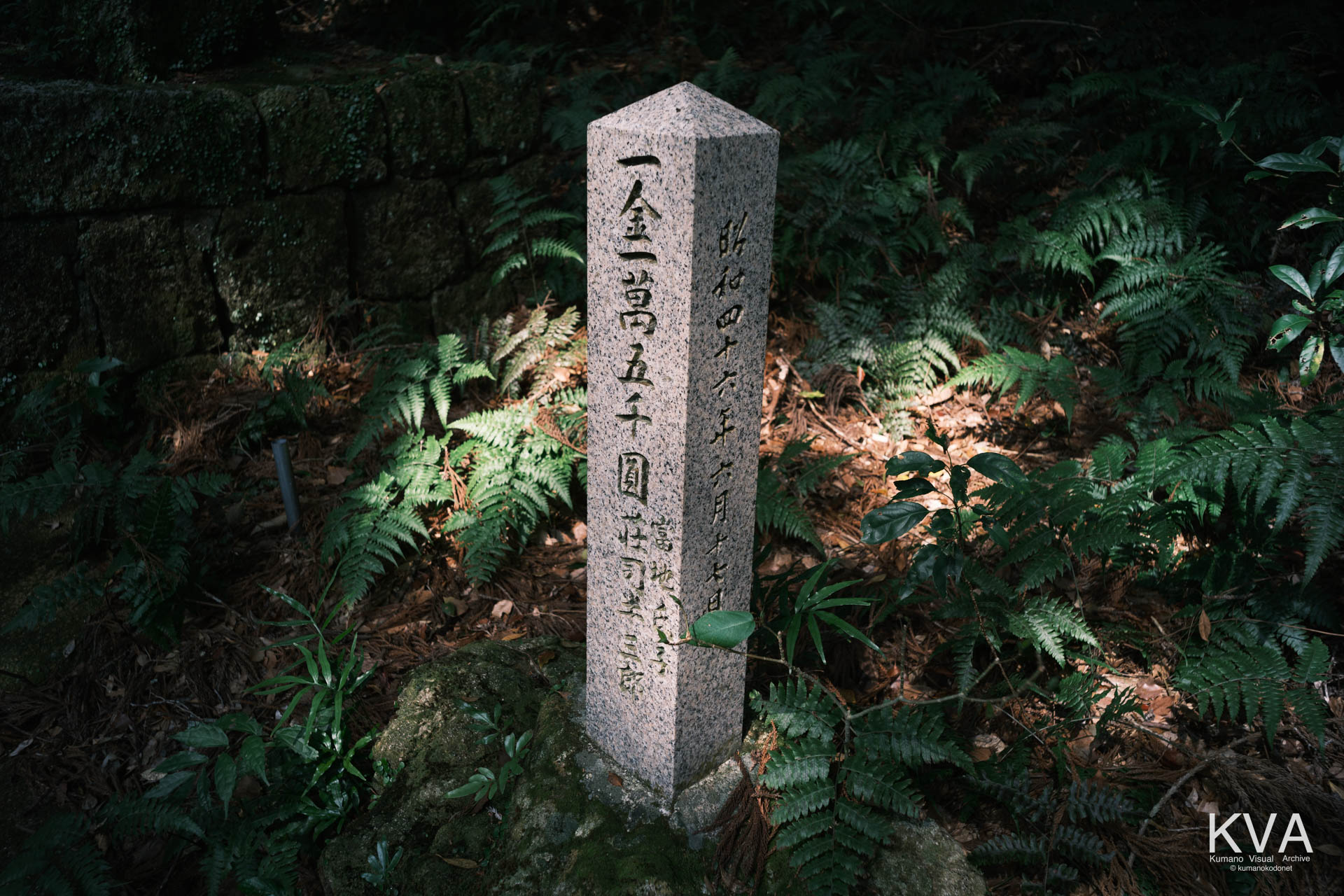 参道に設置された、寄進金額「一金一萬五千圓」と日付、人名が刻まれた石柱