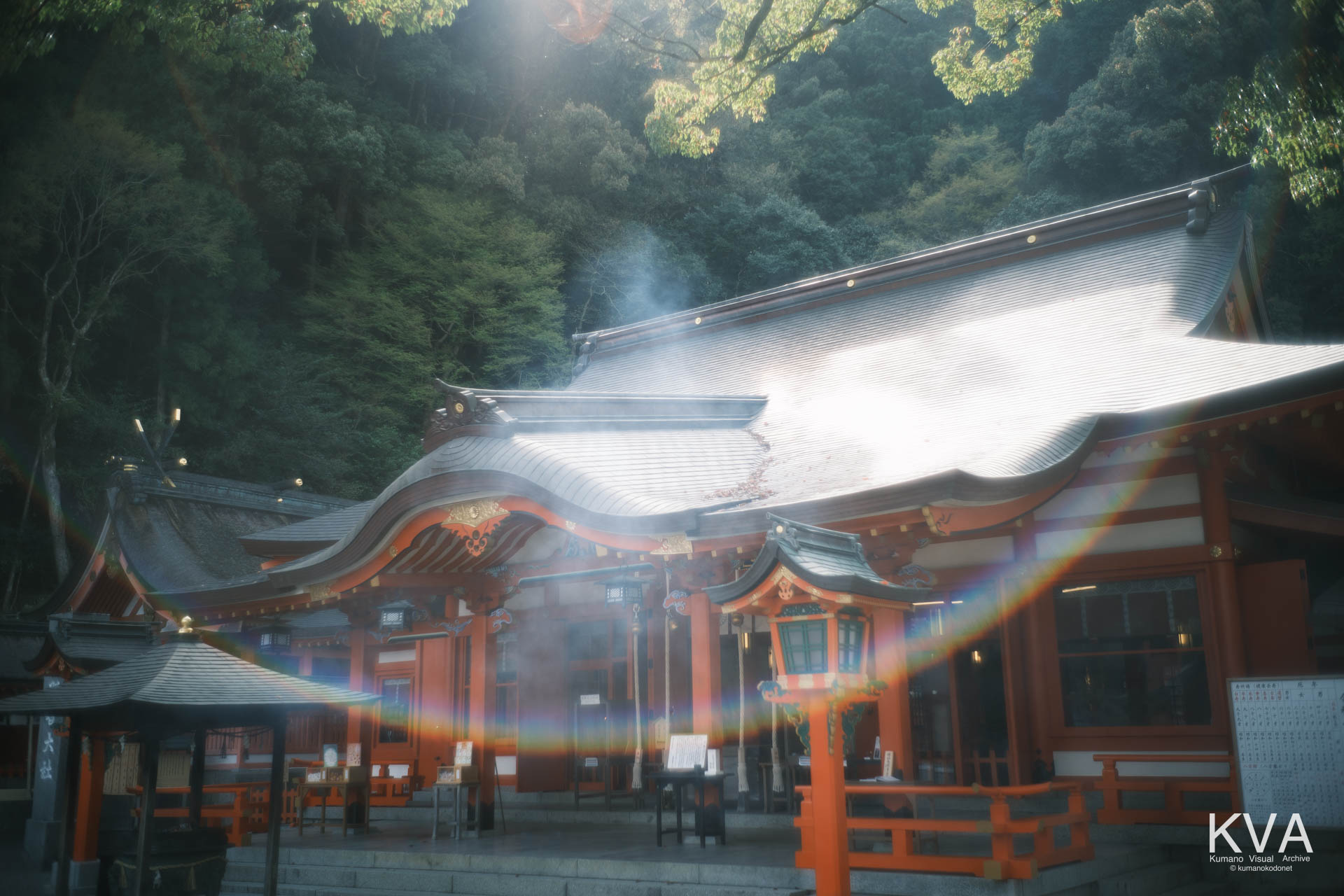 熊野那智大社の社殿と、差し込む強い太陽光による虹色のフレア（ゴースト）