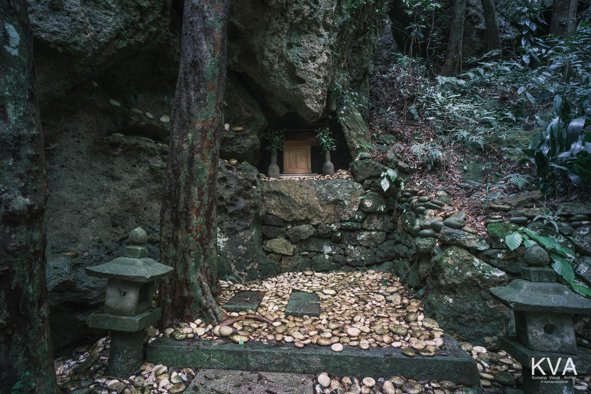 岩壁の水蝕洞穴(自然成岩窟)に祀られた祠と奉納された無数の白石