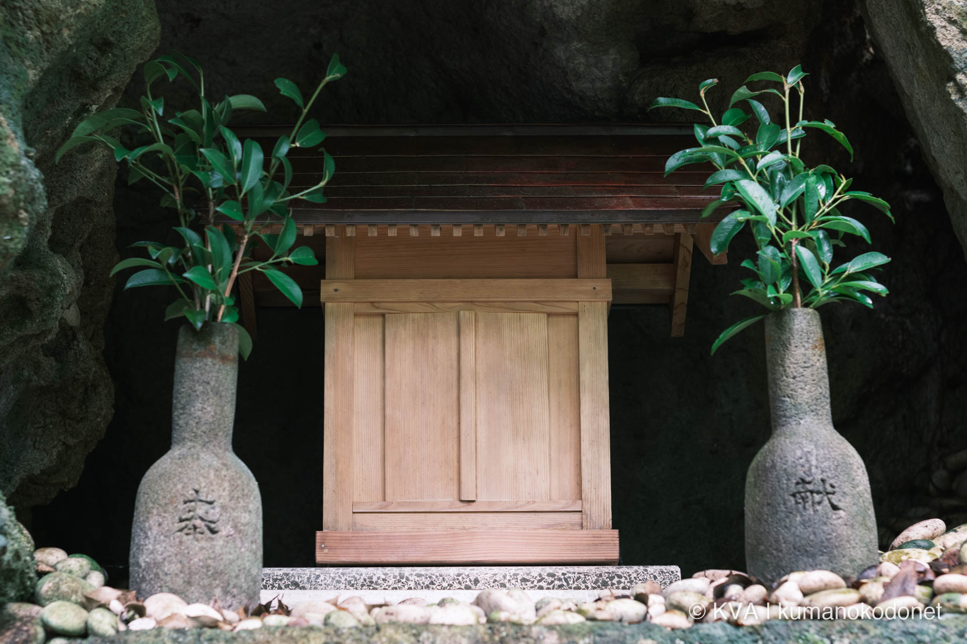 水蝕洞穴の自然成岩窟内に佇む祠と奉納瓶子(石製徳利) 礼拝対象の御神体