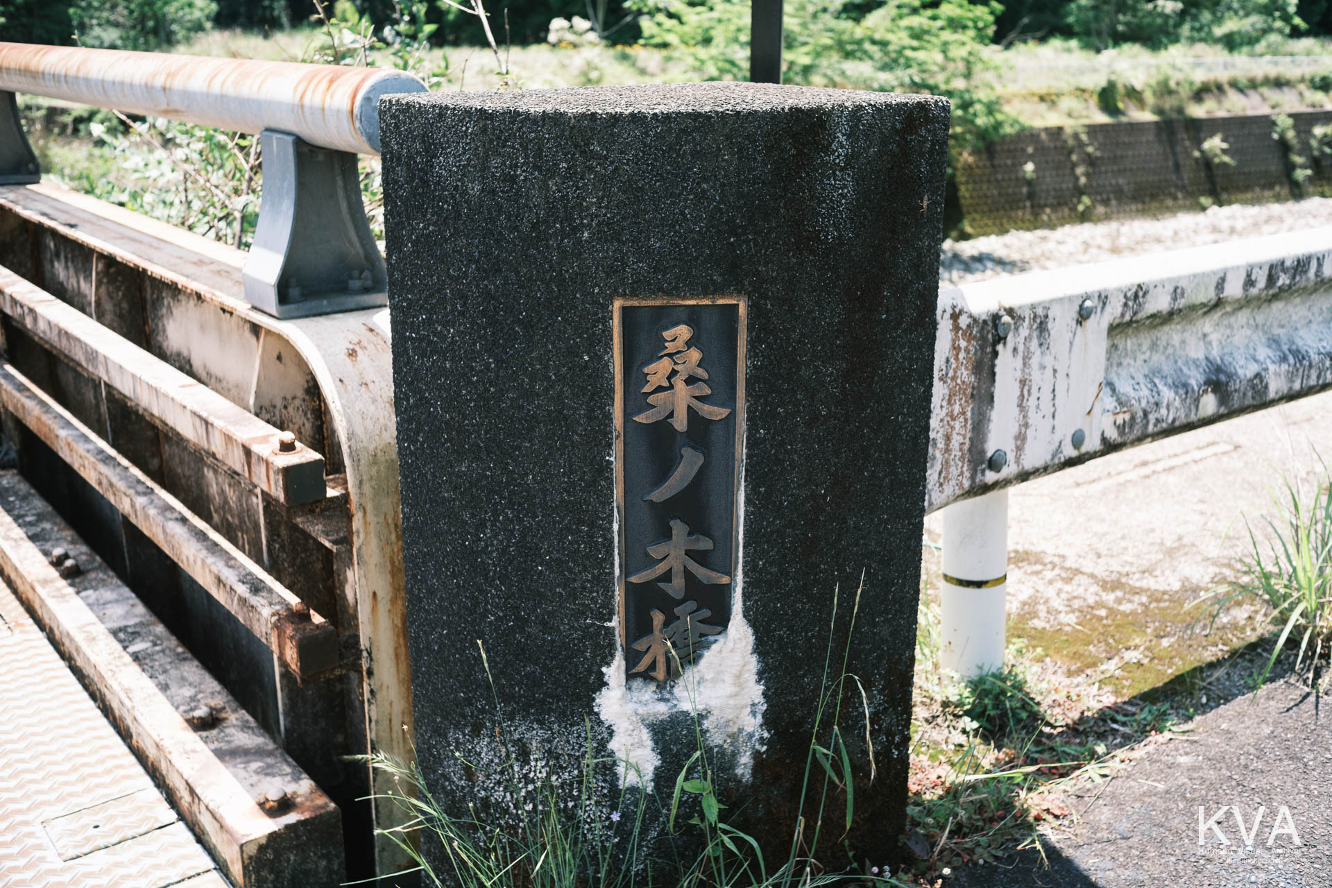 黒いコンクリートの親柱に「桑ノ木橋」と刻まれたブロンズの銘板