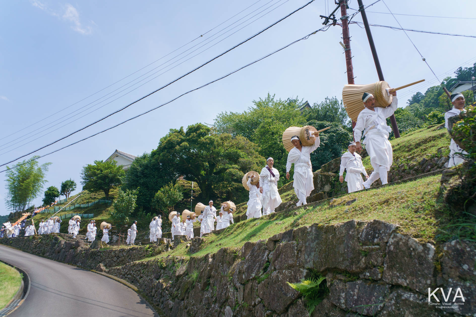 白装束の男たちが大松明を担いで進む扇神輿渡御祭