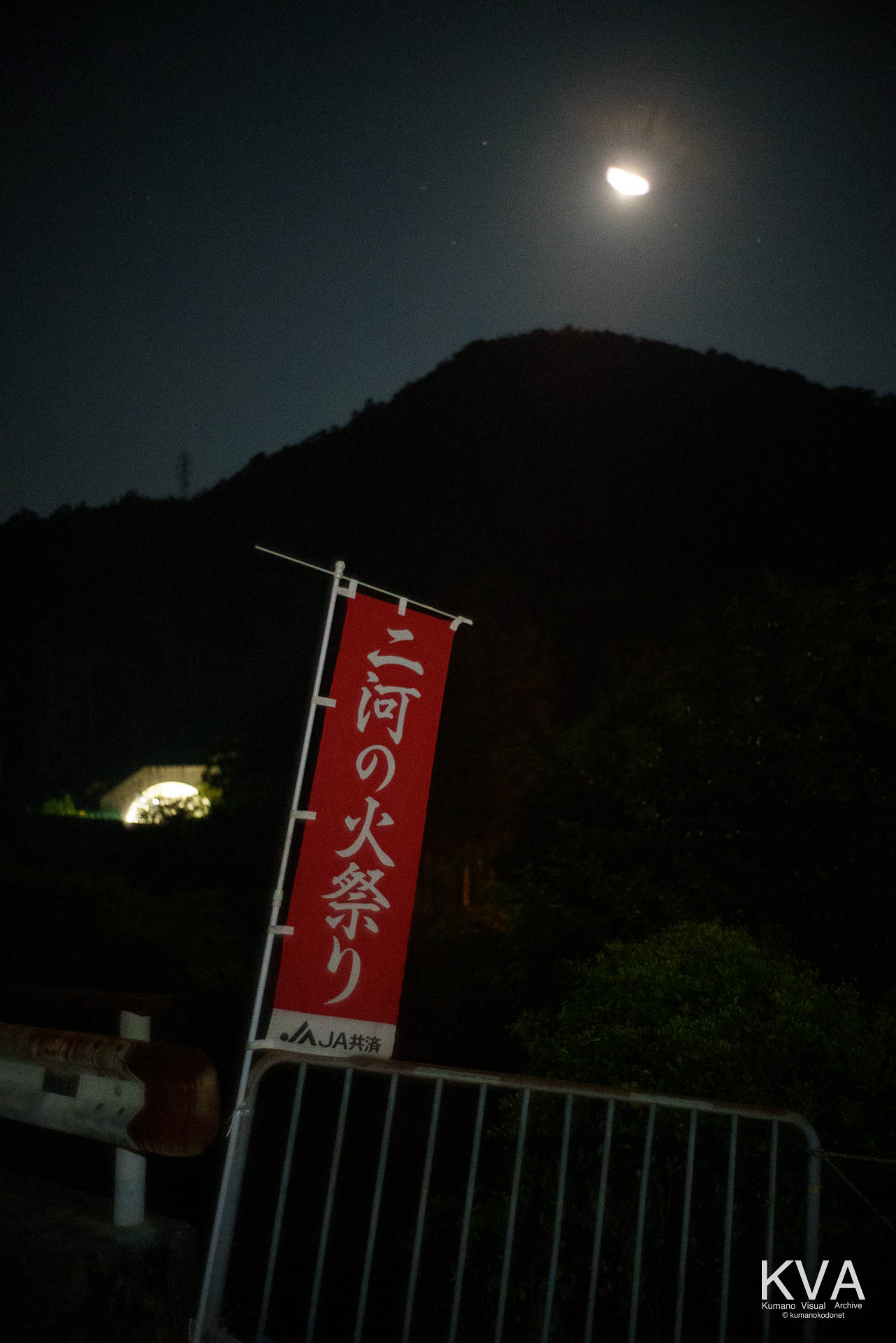 「二河の火祭り」ののぼり旗と那智勝浦新宮道路のトンネルおよび上空の月