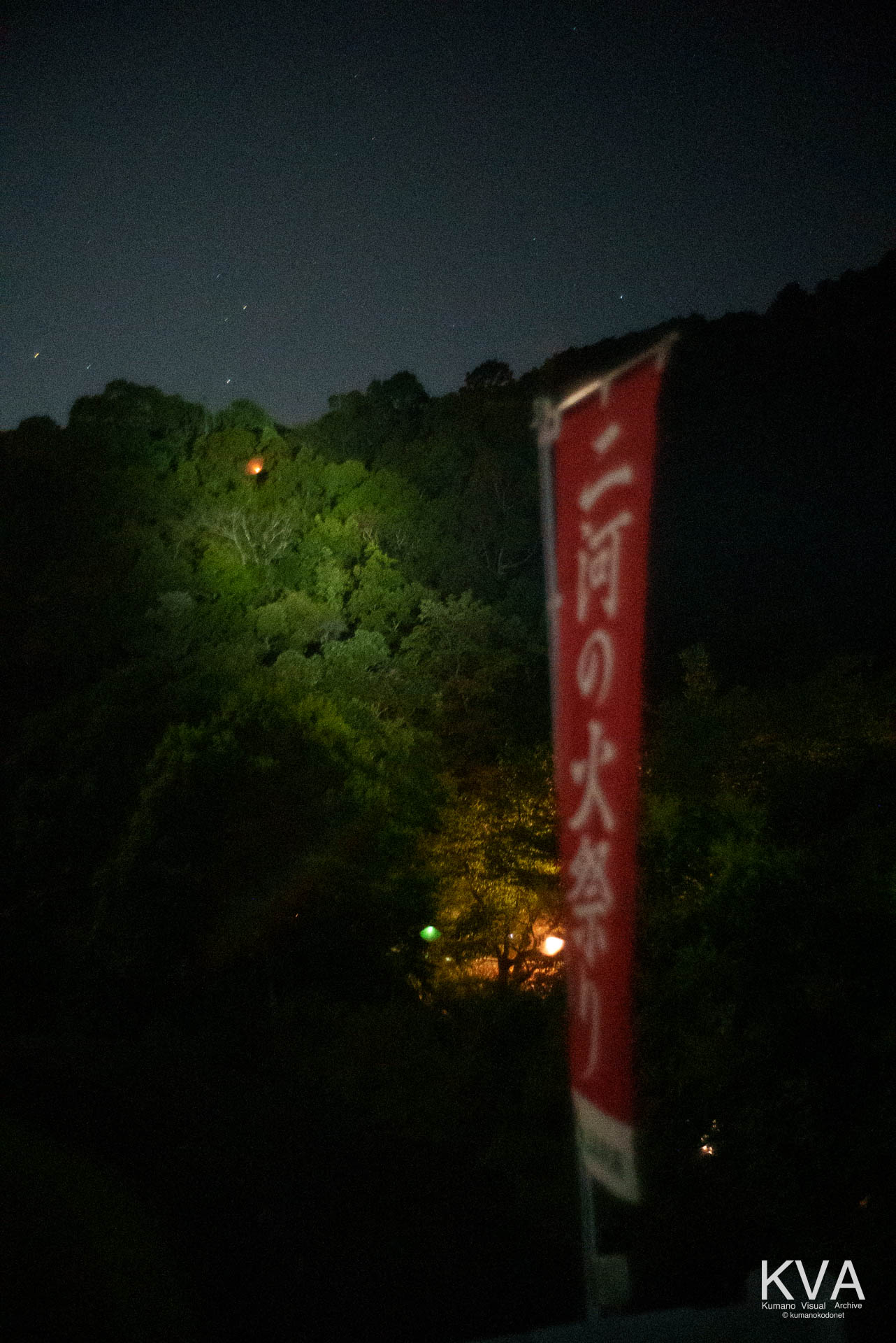 消防団の投光器によって照らし出される裏山の目神八幡神社社前