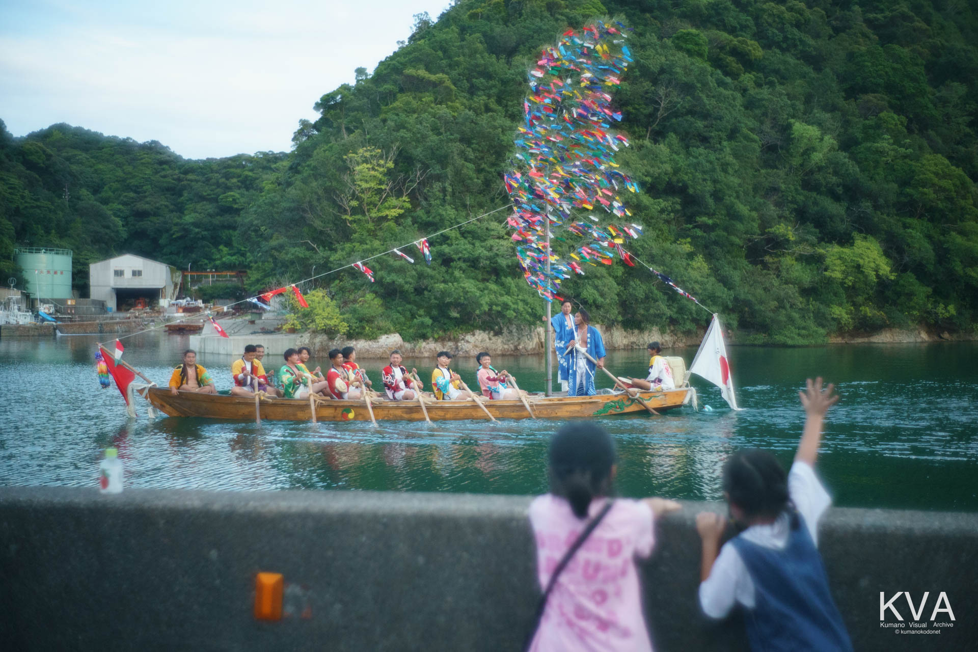 舟渡御 (海路還御) にて帰着する愛友会の櫂伝馬に向かって手を振る子どもたち