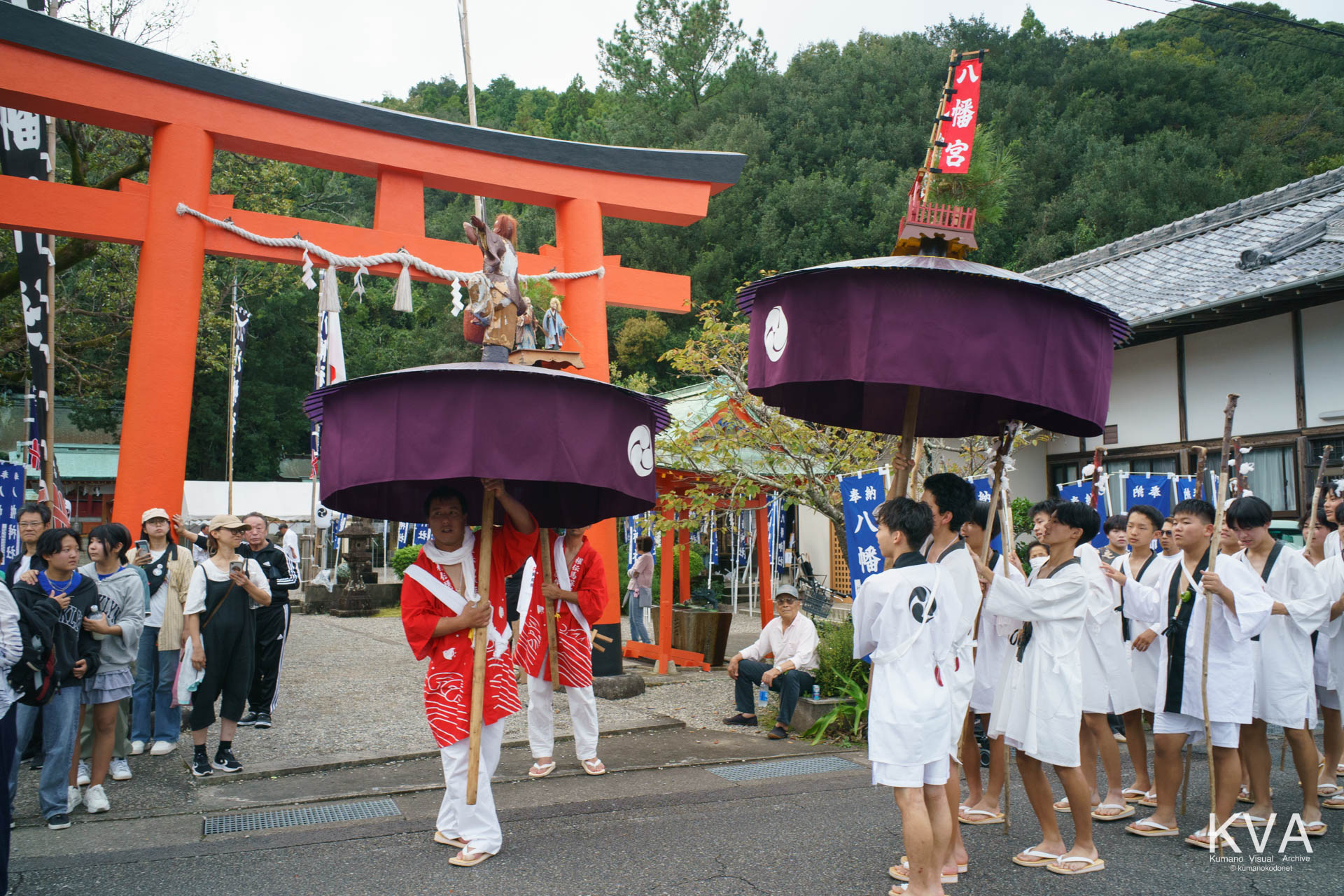 鳥居前を進む傘鉾と餅つき白組の少年たち