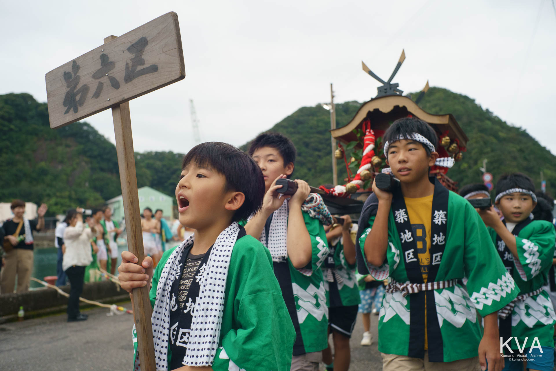 第六区 (築地区) のプラカードを掲げて巡行する子供神輿の少年たち