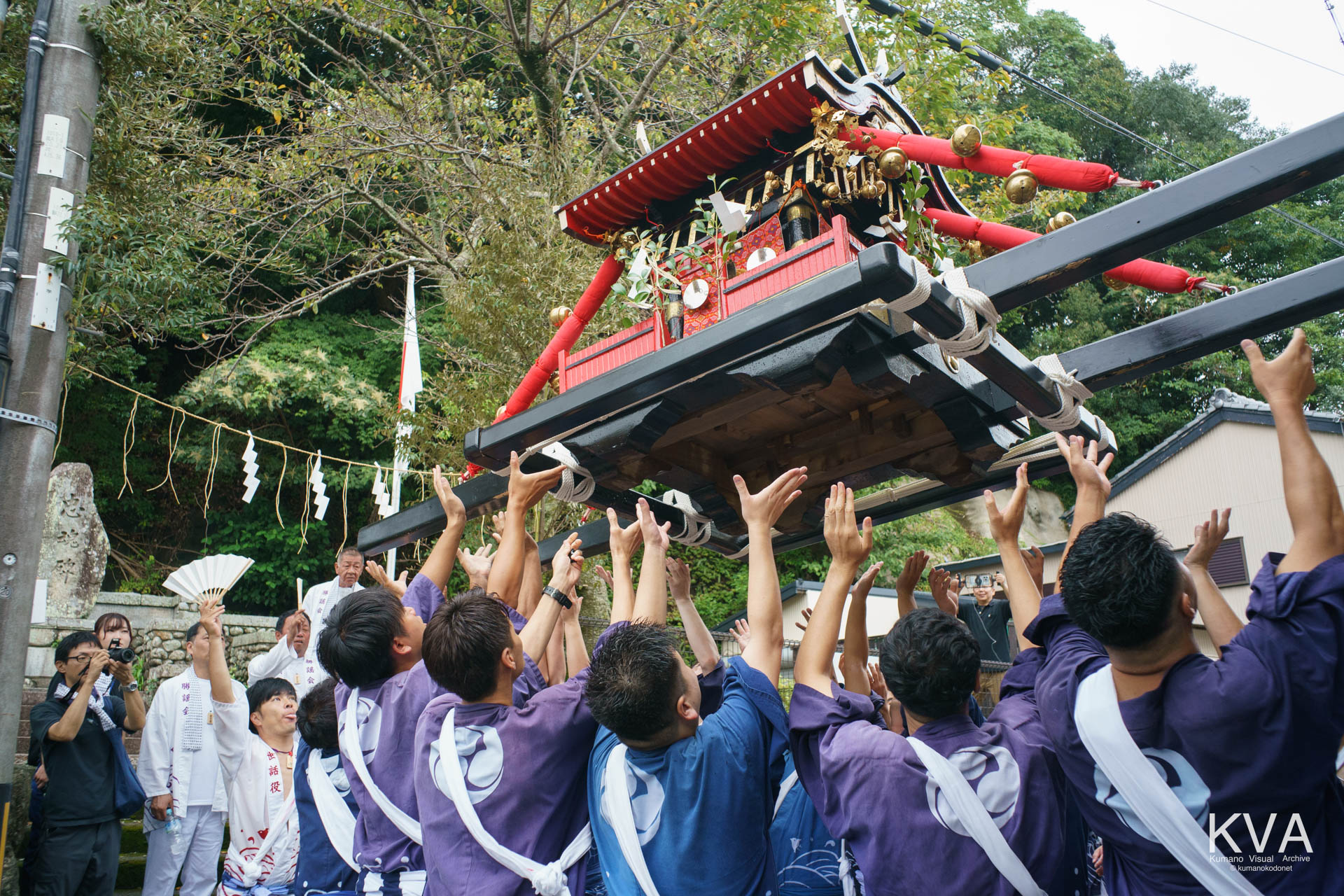忠魂碑前での舟謡奉納を終え神輿を高く差し上げて出発する担ぎ手たち