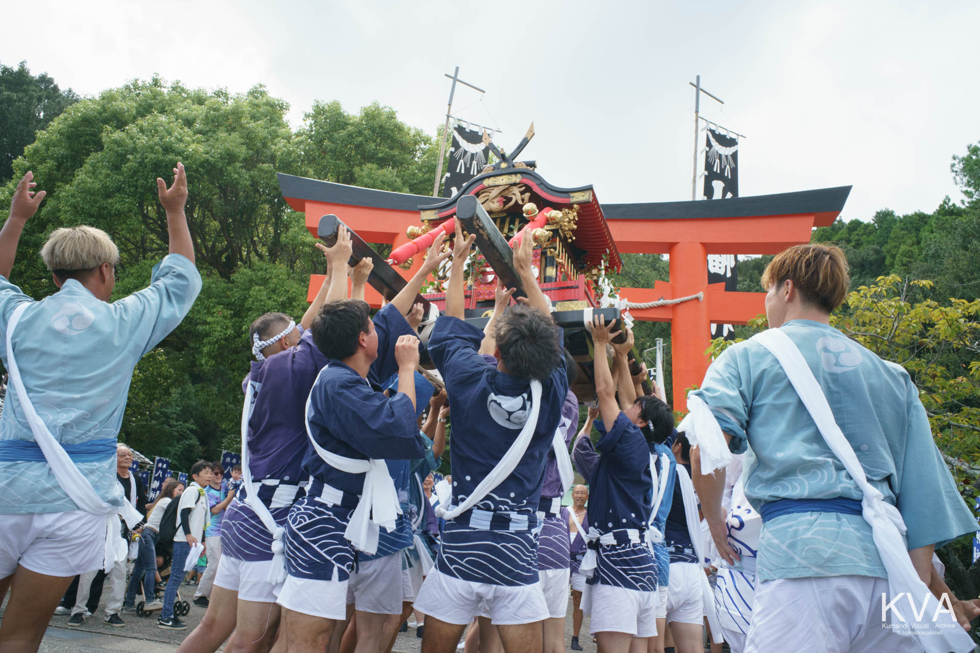 神輿御出門にて鳥居前で神輿を高く差し上げる担ぎ手たち