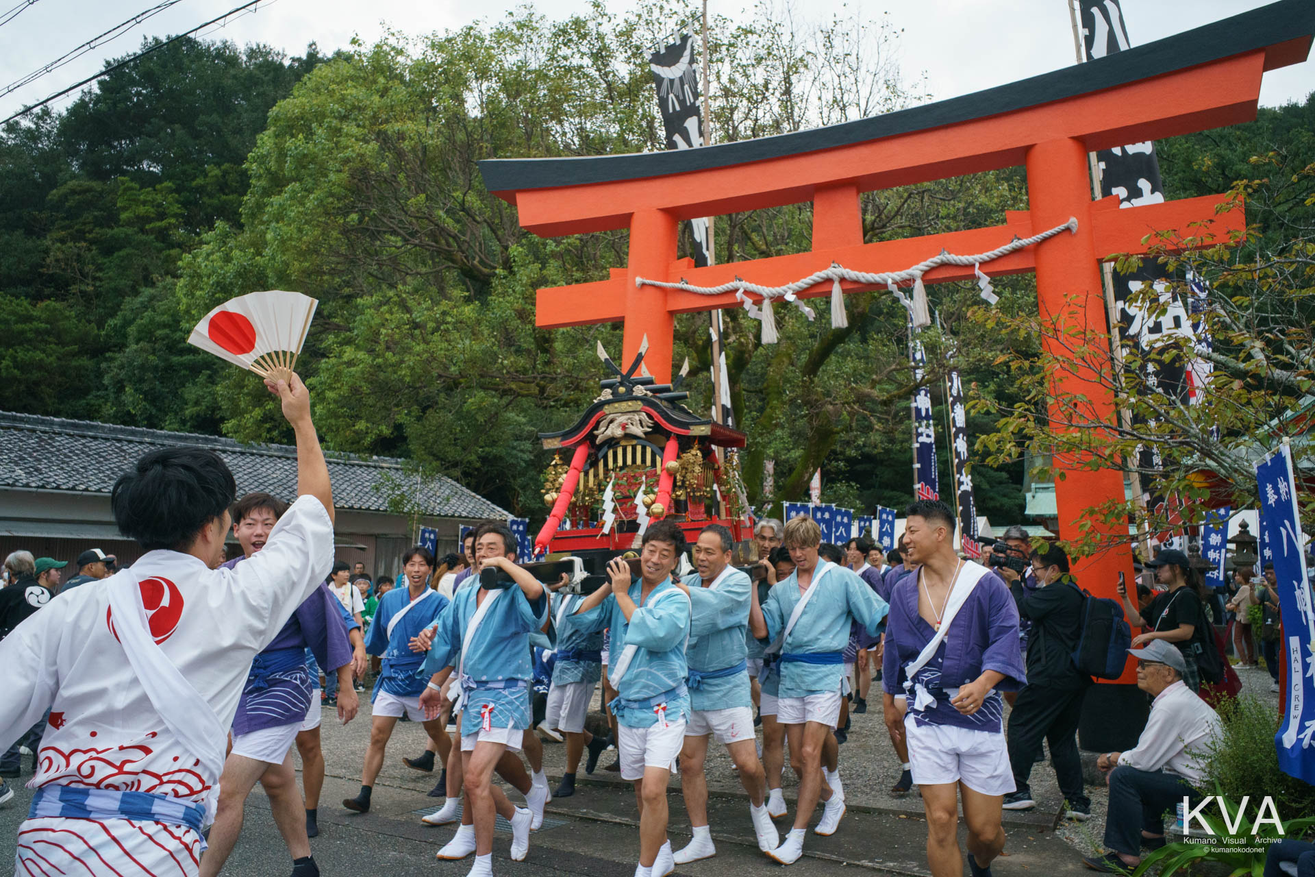 神輿御出門にて鳥居をくぐり境内から渡御へ出発する神輿と担ぎ手たち