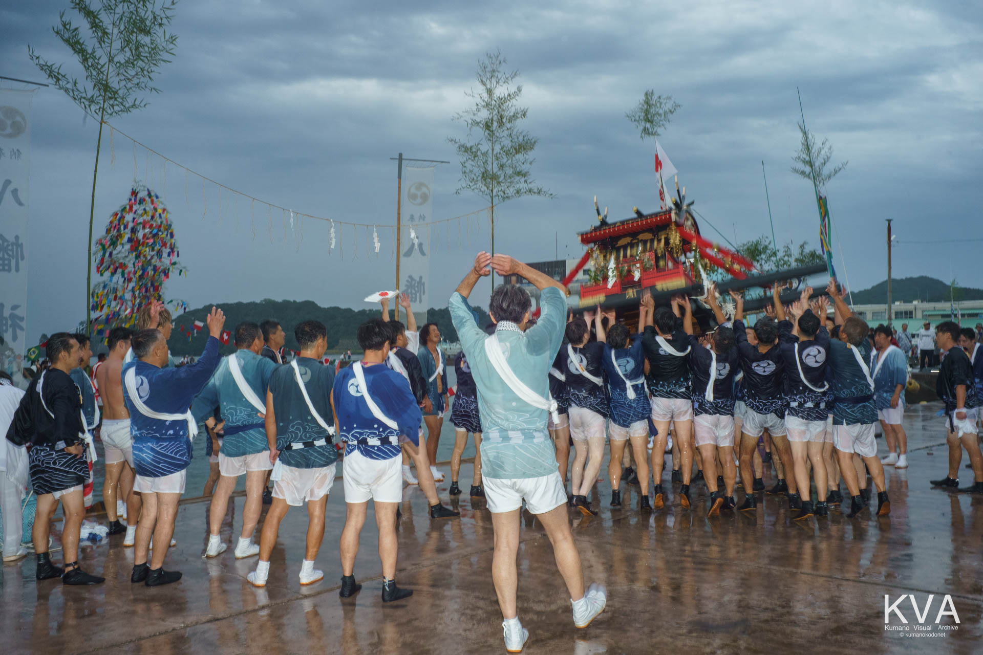 海中神事ののちいざかた船溜の岸壁で神輿を高く差し上げる担ぎ手たち
