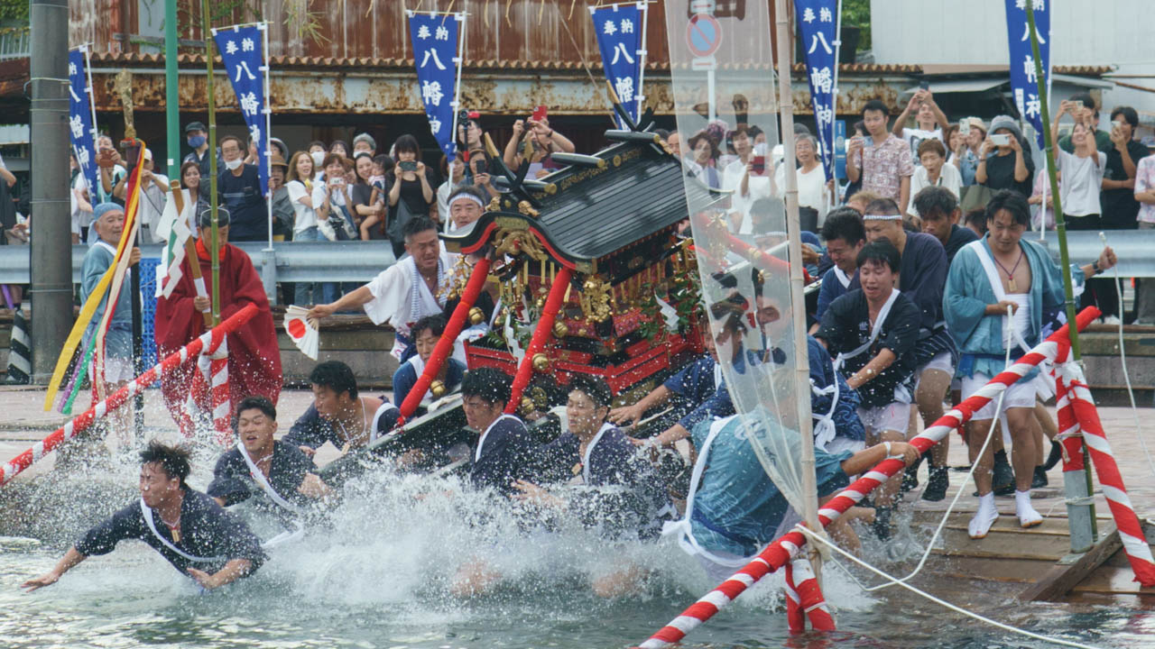 神輿海中神事にて水しぶきを上げて海に入る神輿