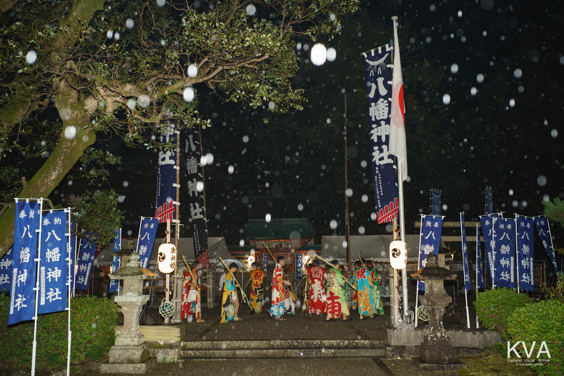 雨の境内に並ぶ愛友会の餅つき歌奉納